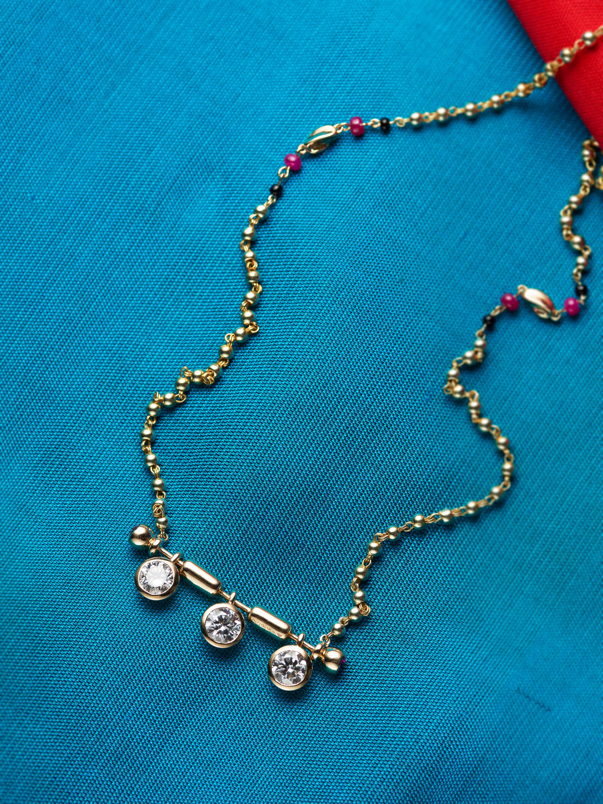 detail view of open setting 14 karat gold mangalsutra pendant