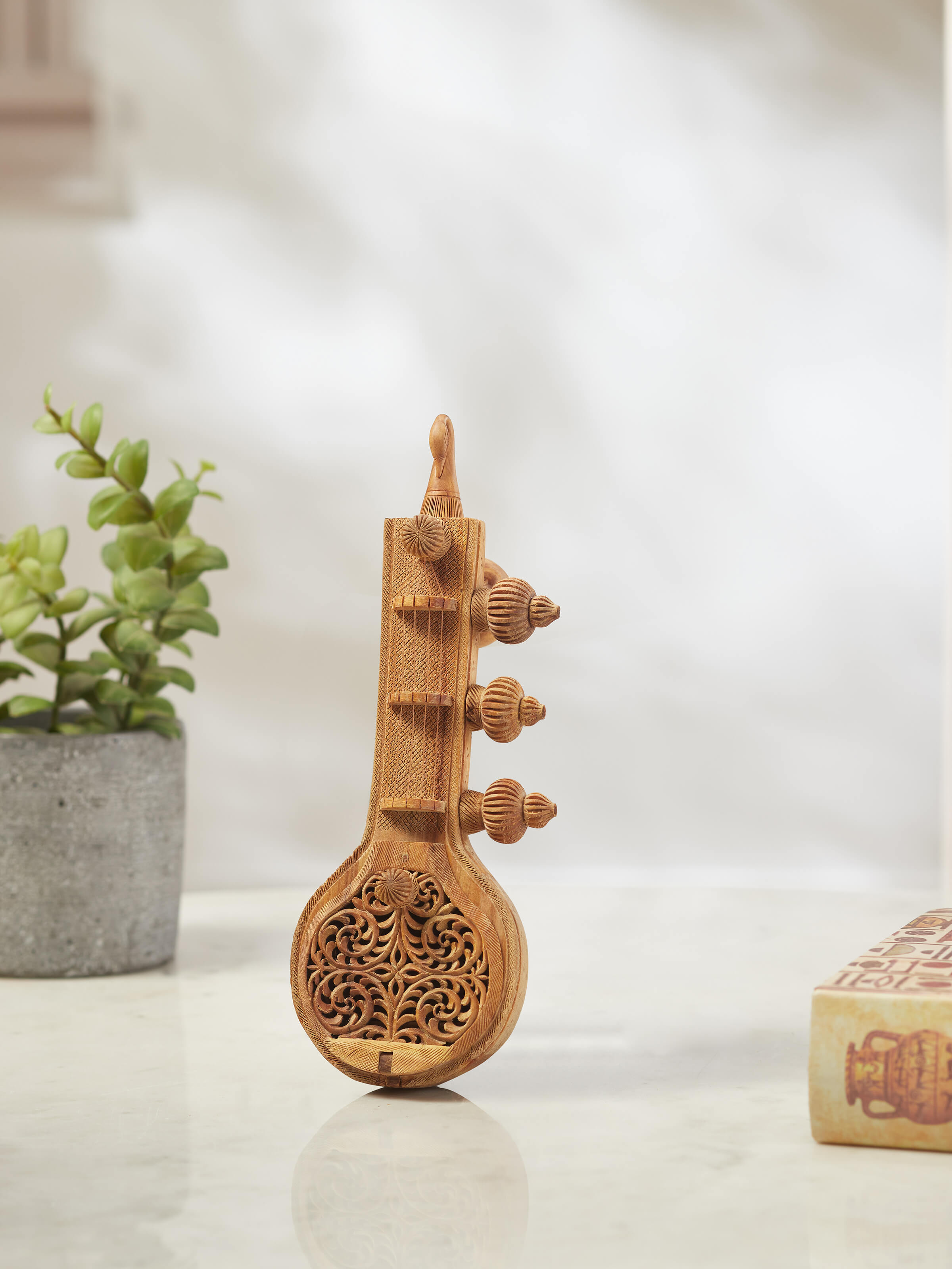 Side view of carved sandalwood Vandana Veena sculpture highlighting detailed craftsmanship