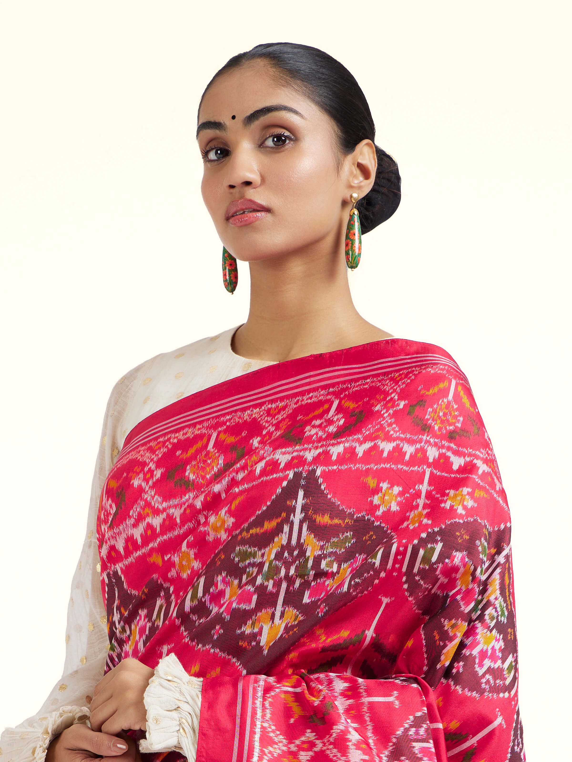 Angled view of red mulberry silk Ikat saree highlighting Ikat weaving technique