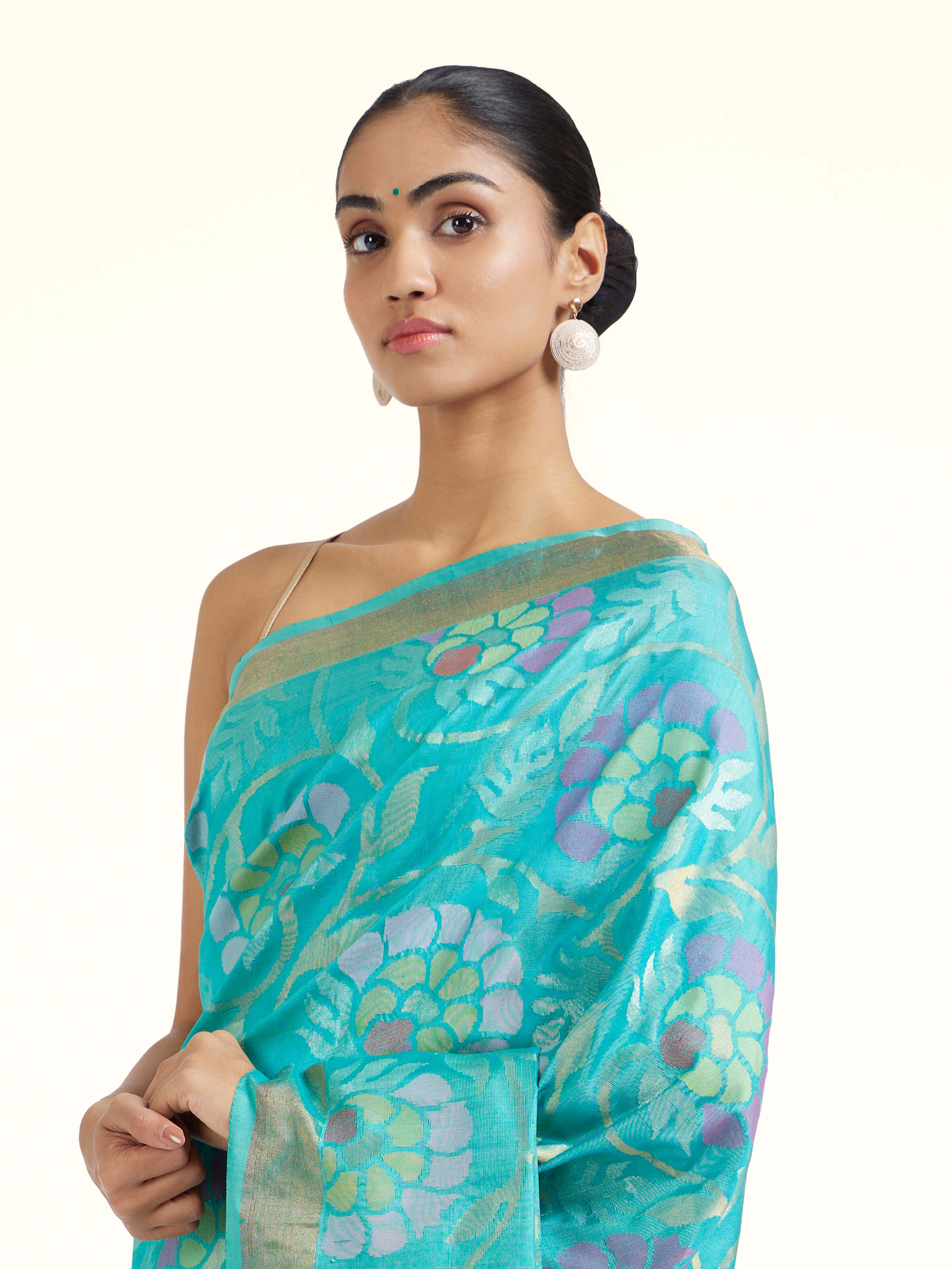 Angled view of turquoise mulberry silk Uppada Jamdani saree highlighting airy weave