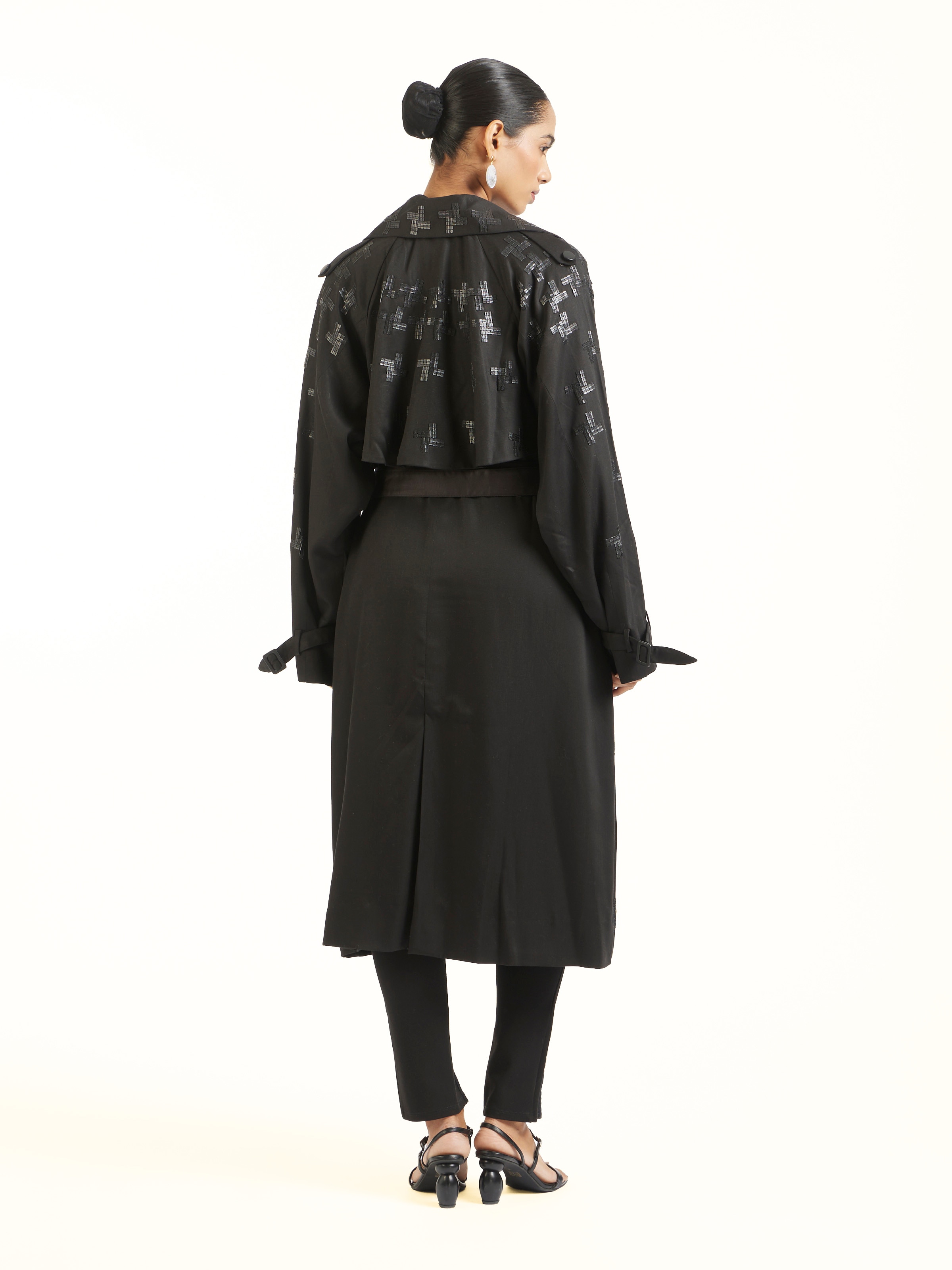 Back view of black hand embroidered houndstooth sequin trenchcoat displaying overall design