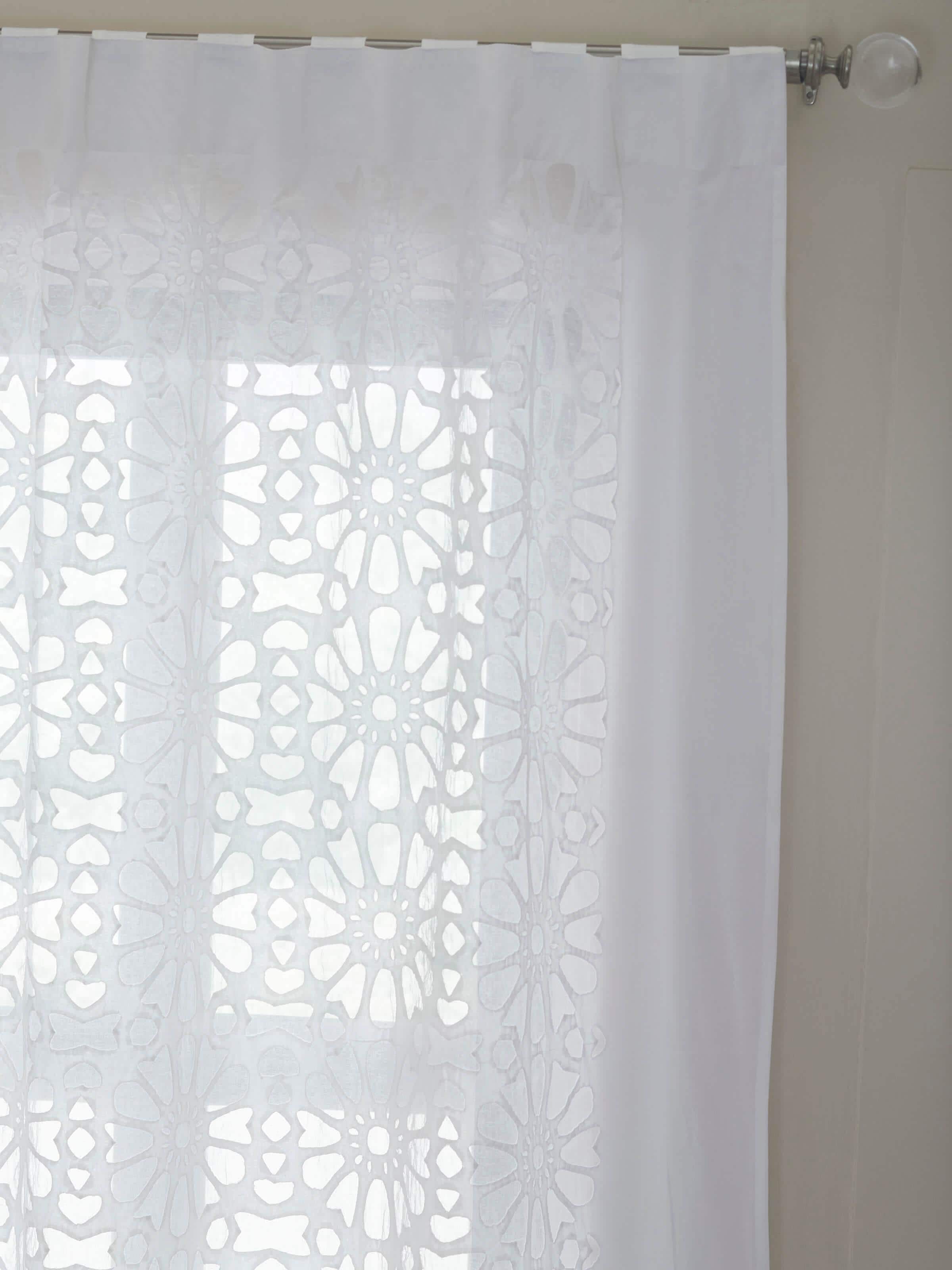 Close-up detail of cotton appliqué jaal pattern on sheer white curtain fabric