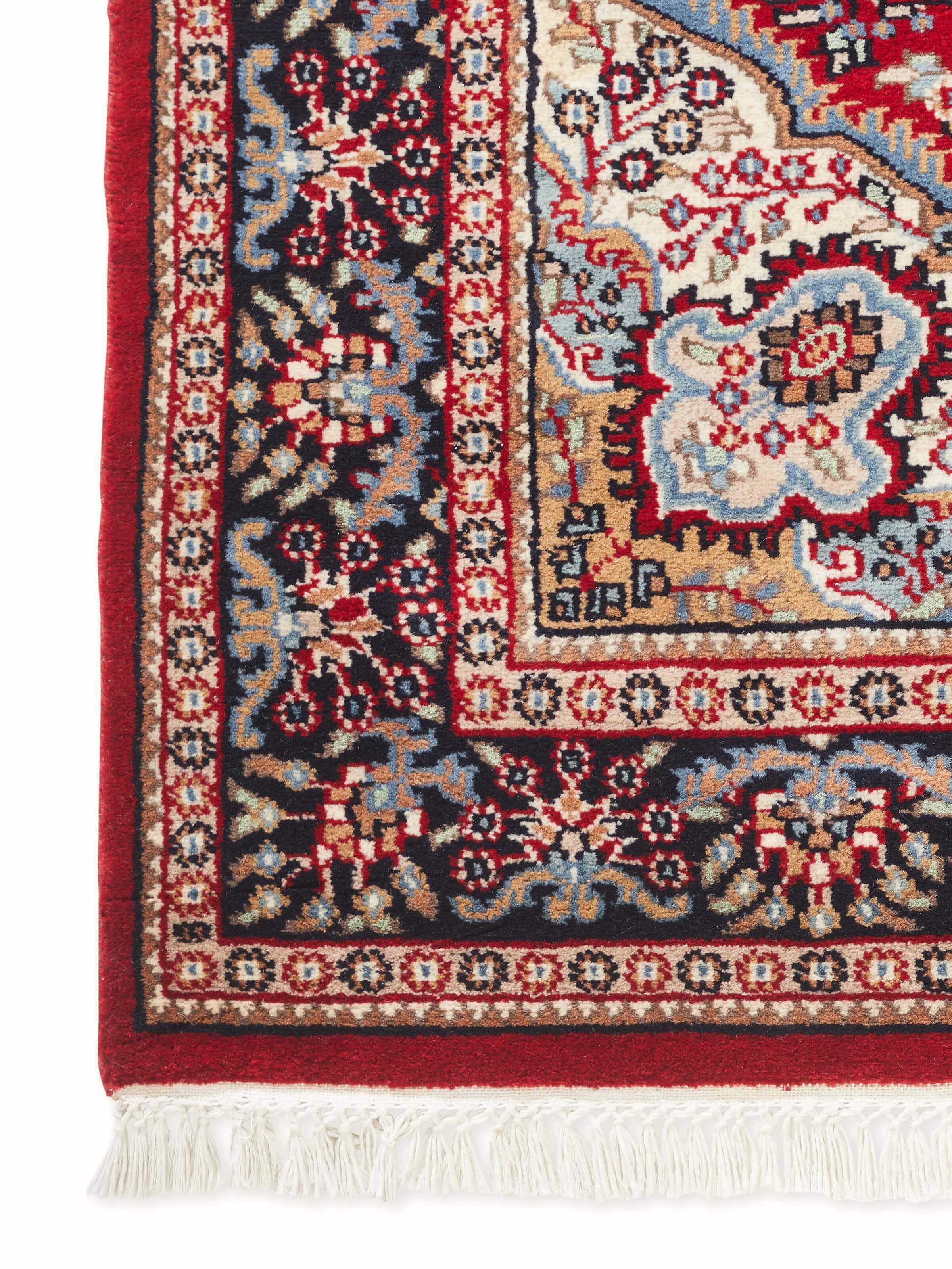 Close-up detail of Persian red hand-knotted Gwalior wool rug with ornate motifs