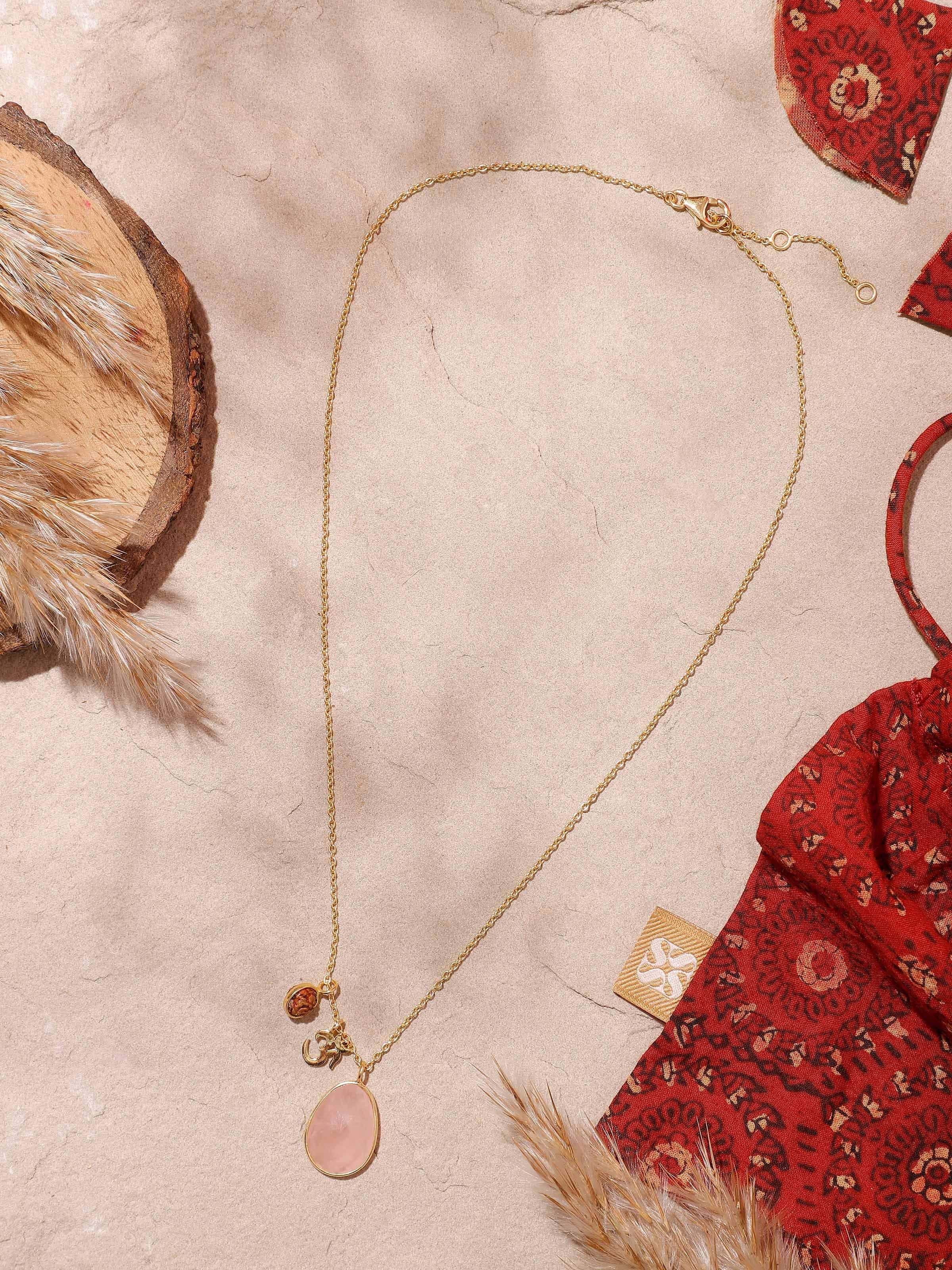 Close-up of Rudraksha, Om Charm & Rose Quartz Necklace showcasing the detailed charm and natural texture of Rudraksha