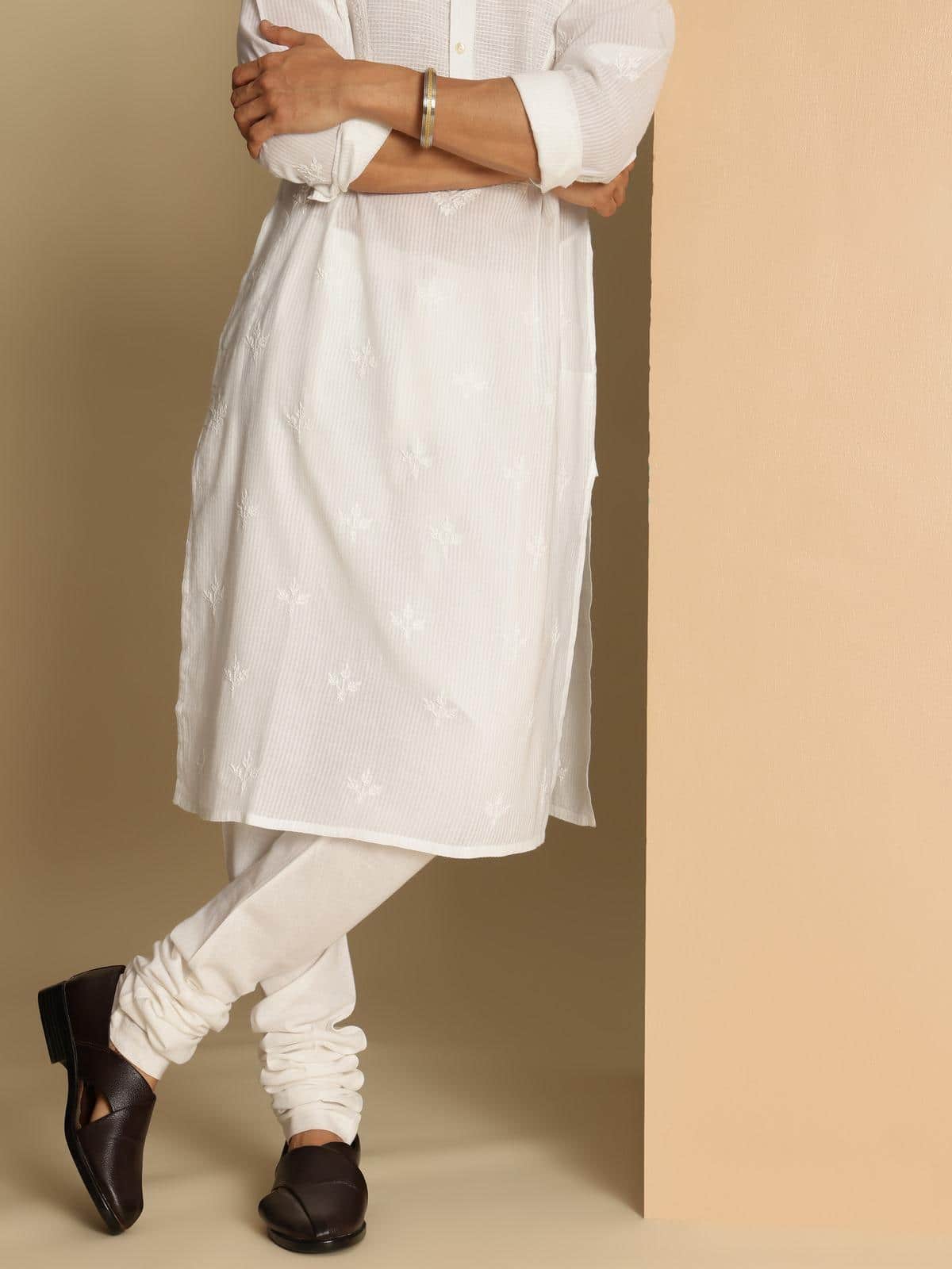 Side lifestyle view of white elasticated churidar paired with ethnic wear for a traditional ensemble.