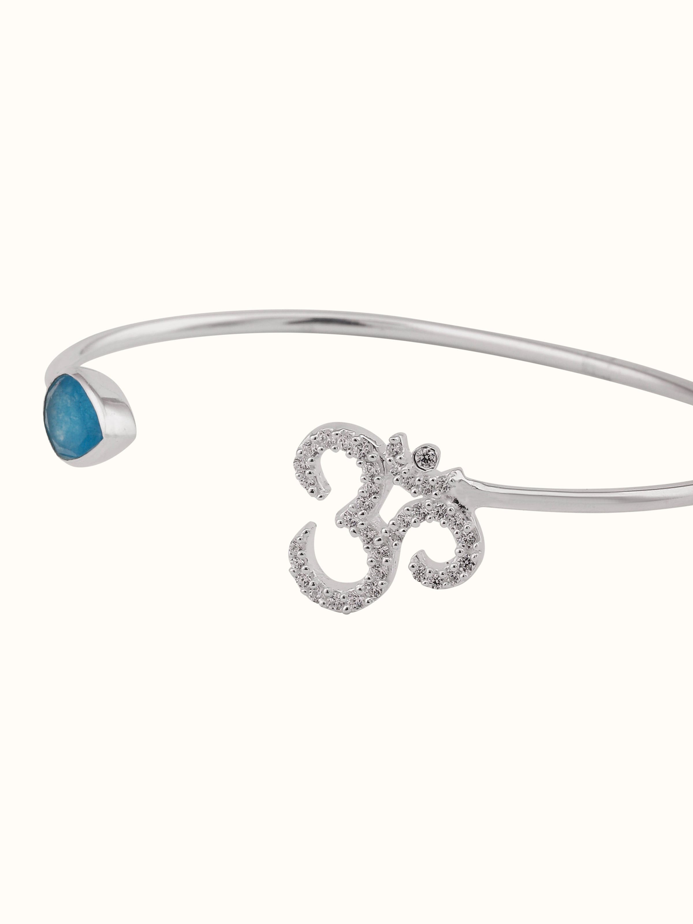 Top view of green-white jade bracelet with Om symbol, showcasing gemstone textures and design