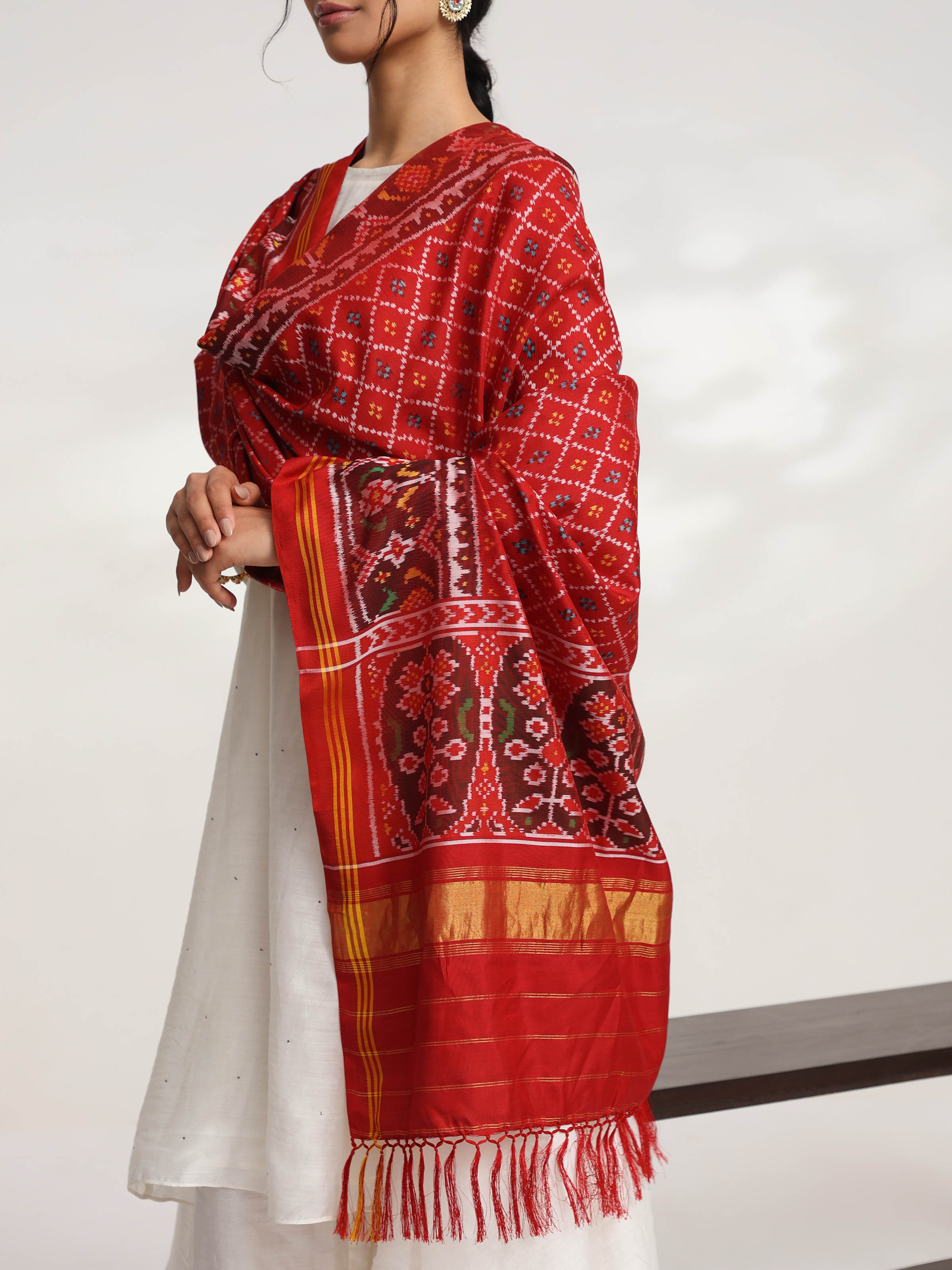 Detailed side view of red silk semi ikat Patola dupatta showcasing woven motifs