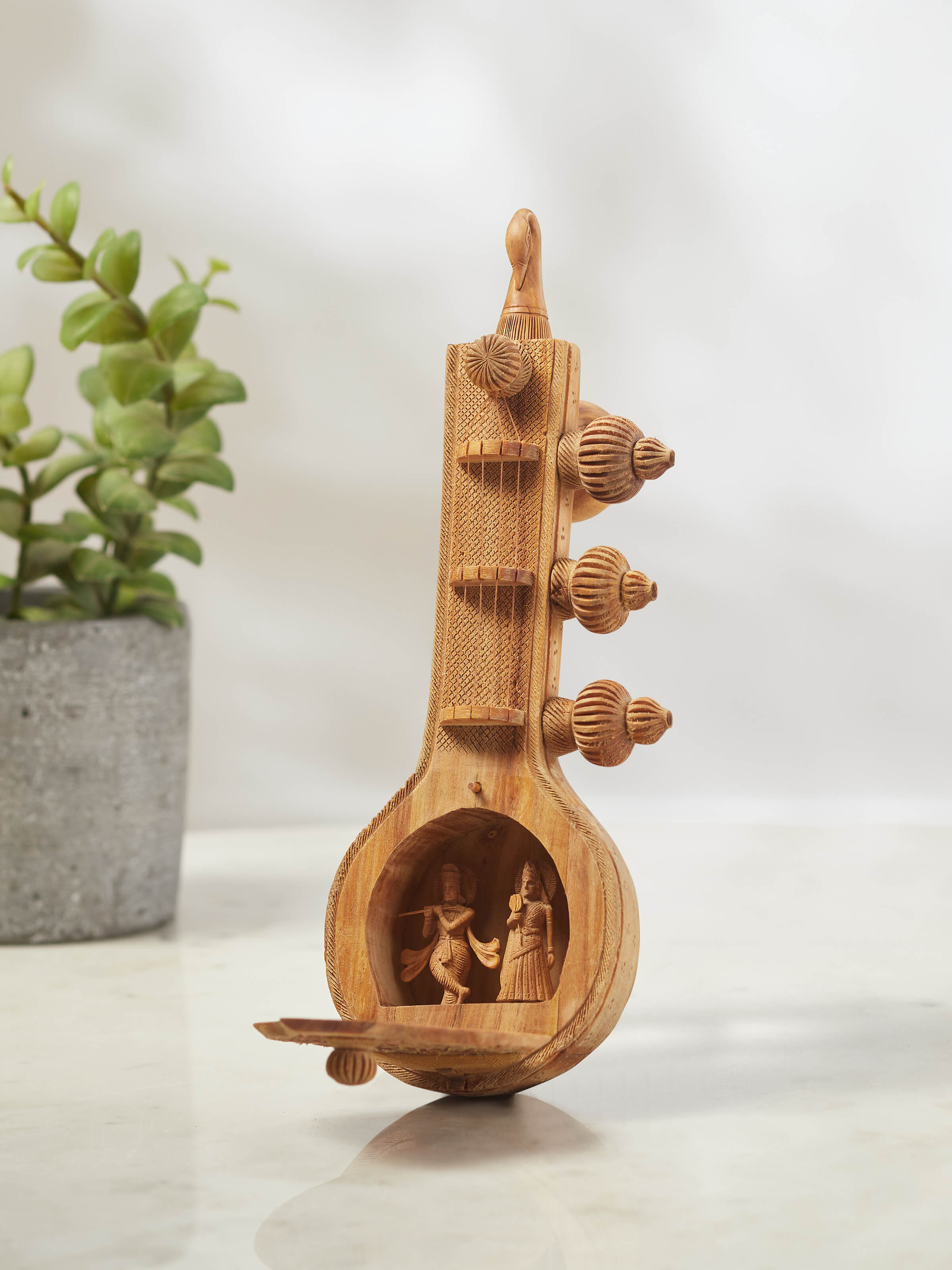 Close-up of carved sandalwood Vandana Veena sculpture illustrating intricate design