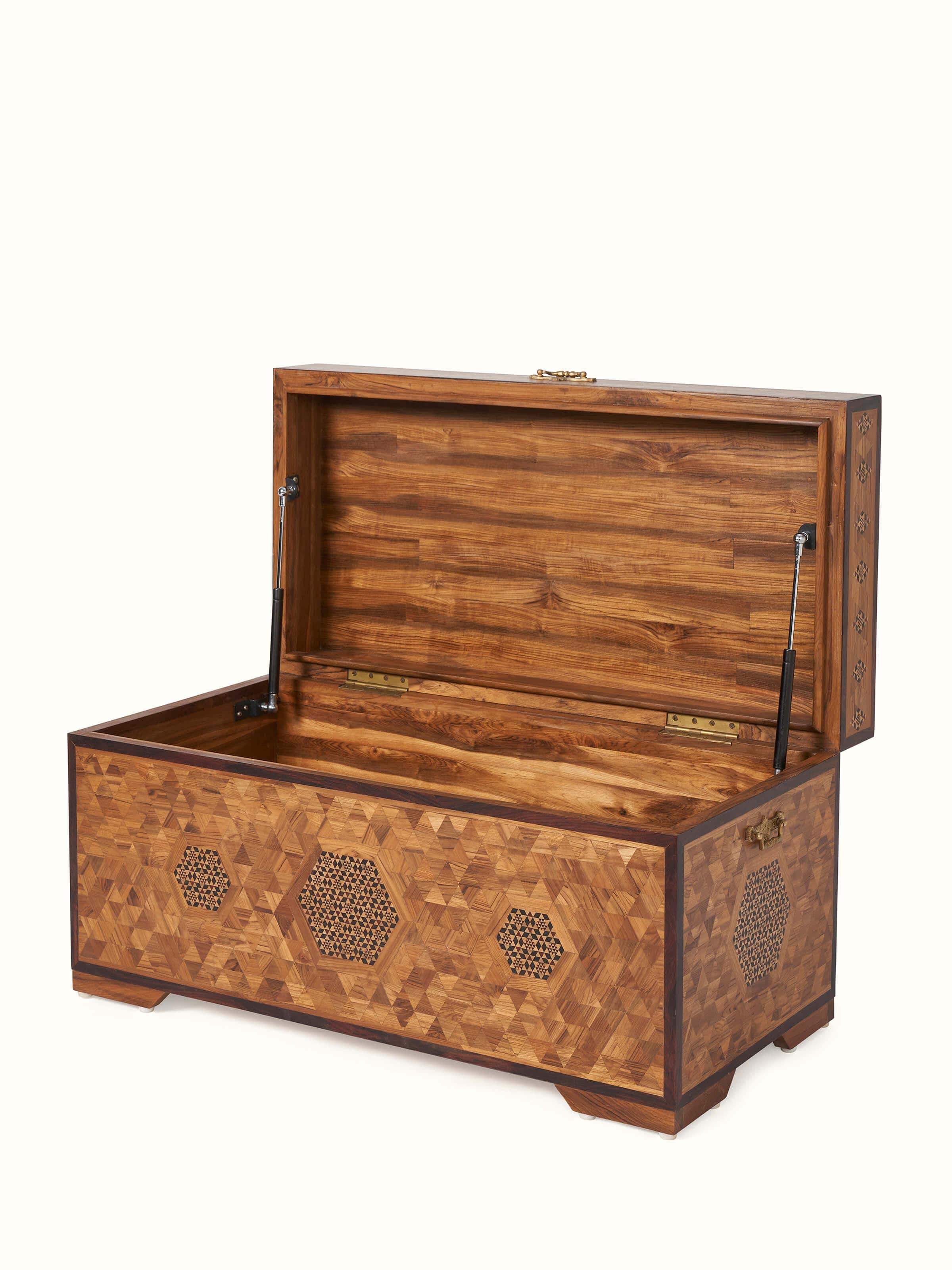 Side view of teak wood trunk with marquetry, highlighting the design's craftsmanship and durable build.