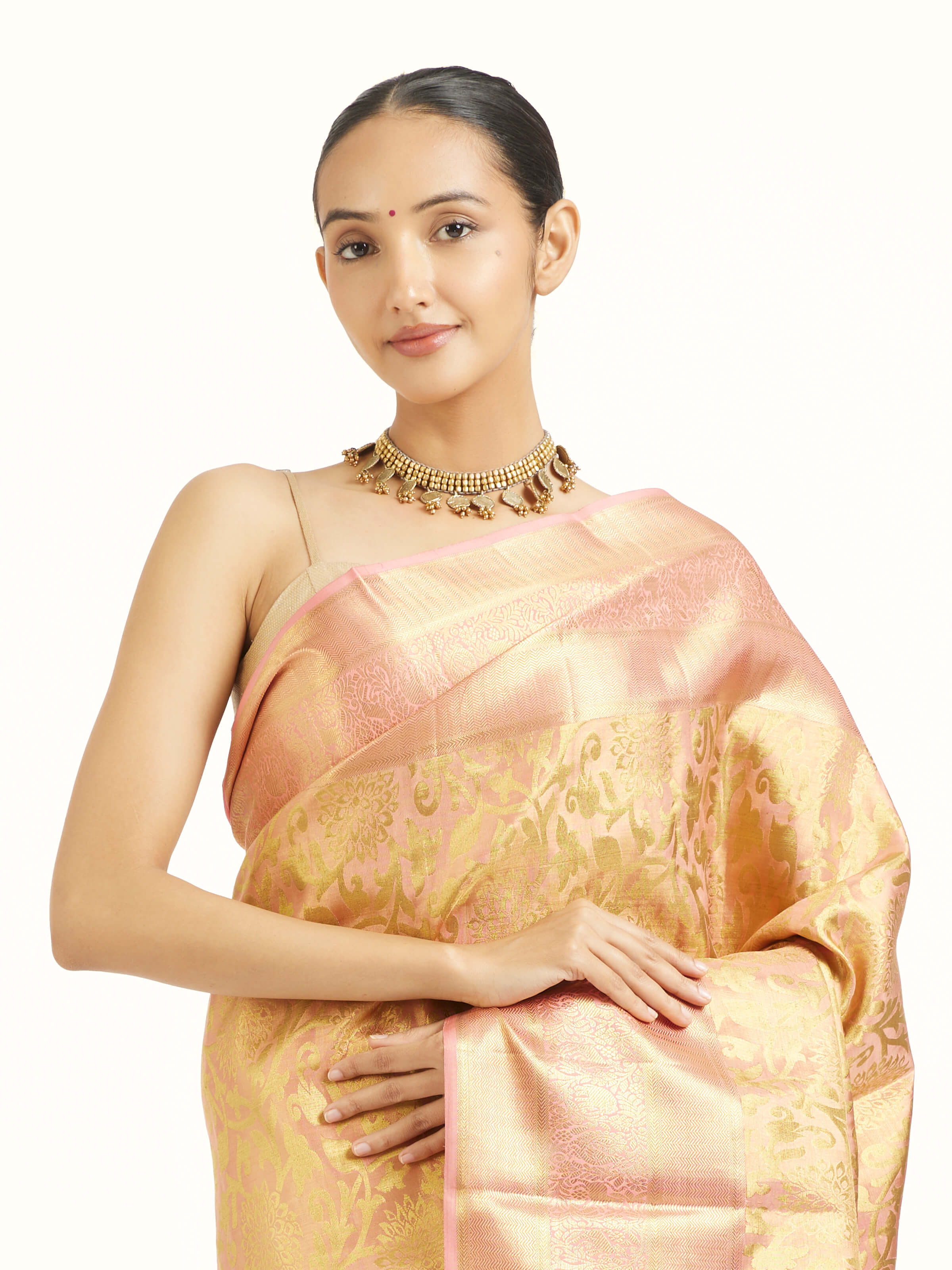 Angled view of peach silk Kancheepuram saree highlighting traditional weave and sheen