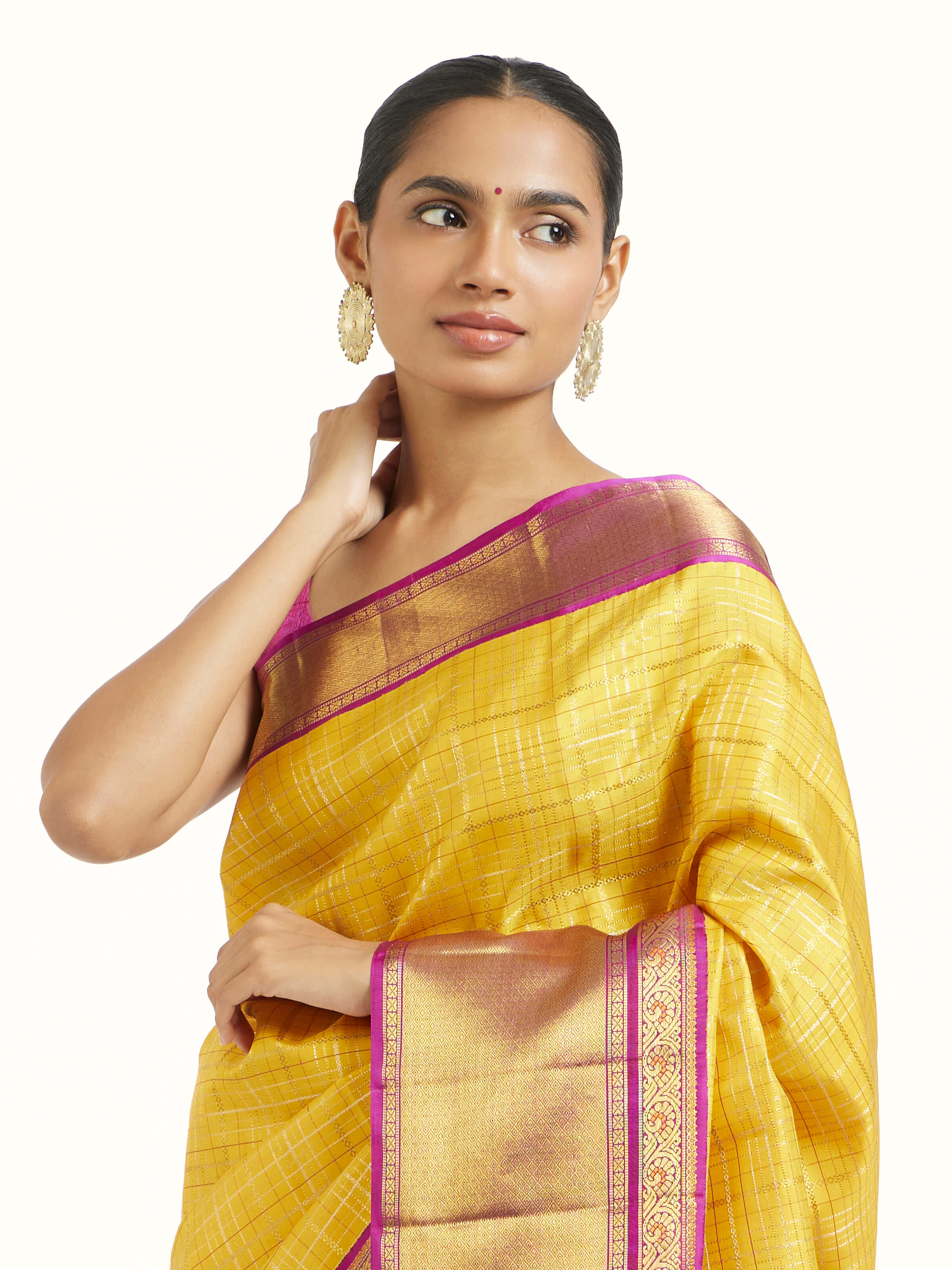 Angled view of yellow silk Kancheepuram saree highlighting lustrous weave