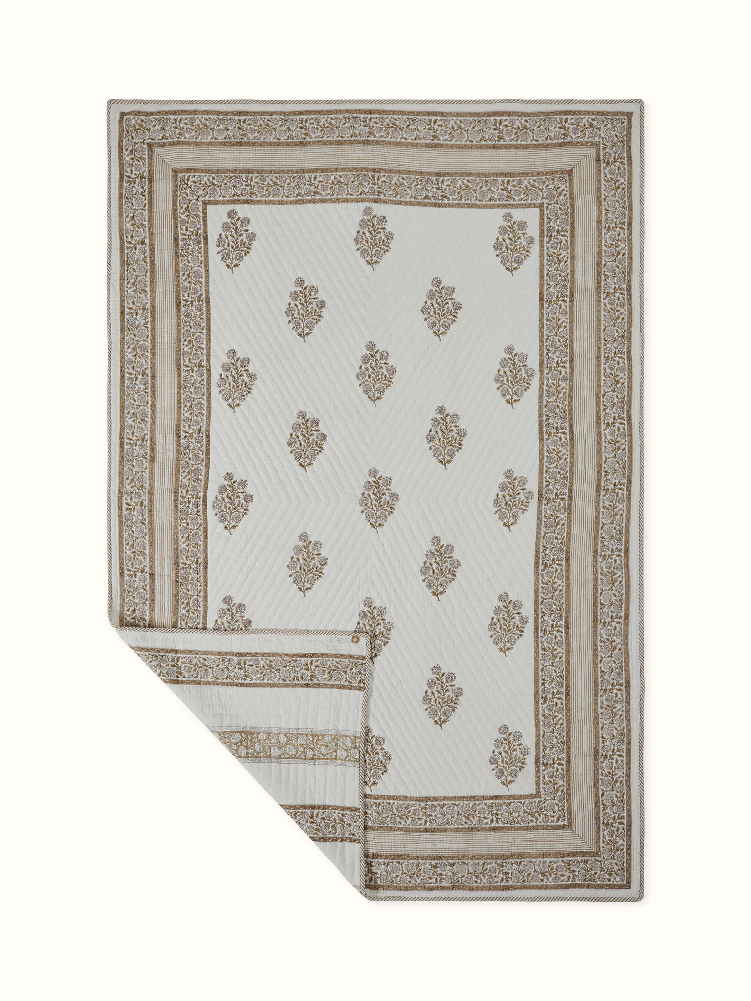 Close-up of block printed buta motifs on beige cotton double quilt from Saha collection