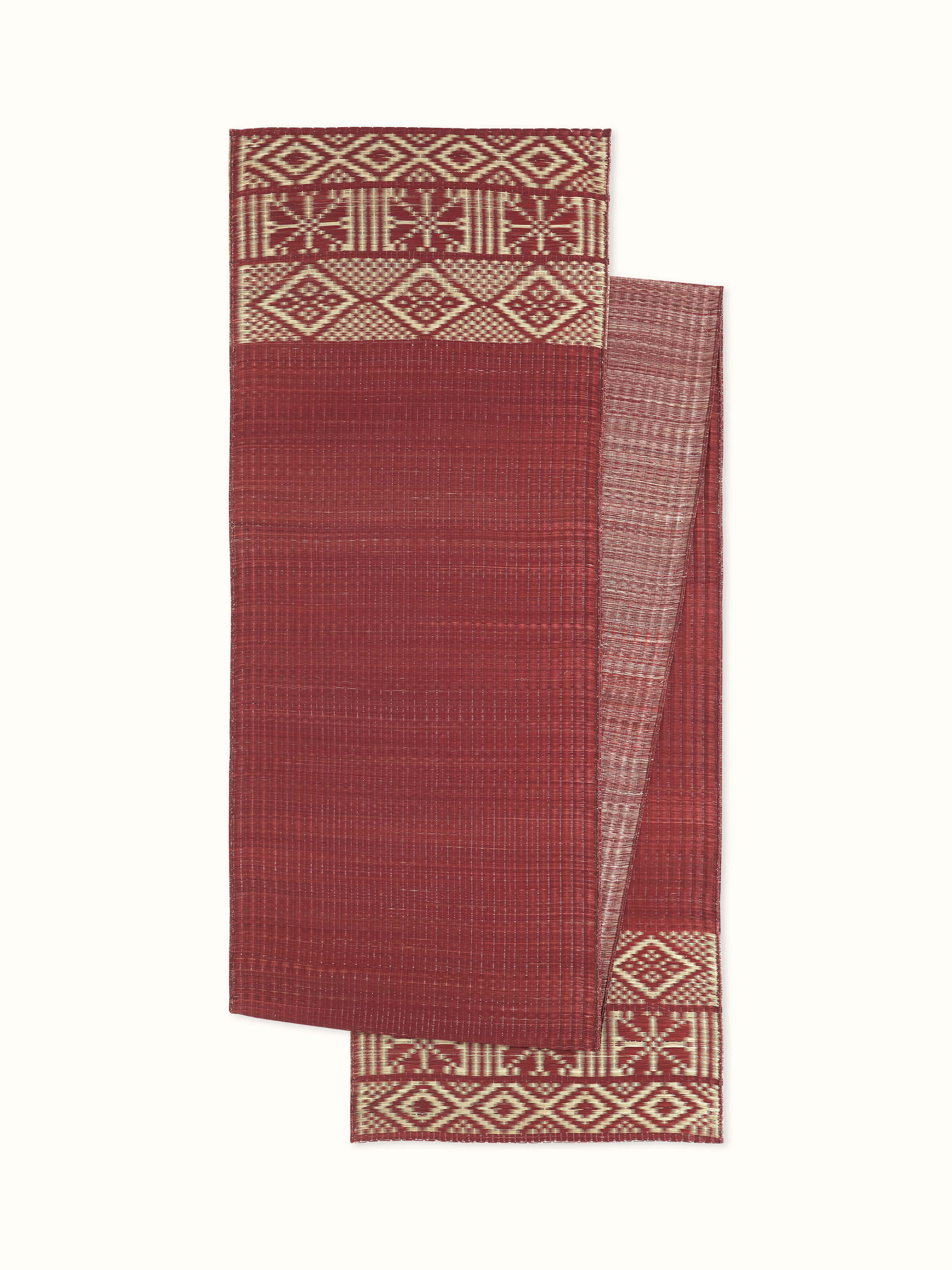 Front angled view showcasing the vibrant red folk geometric pattern on the natural fibre Madurkathi table runner
