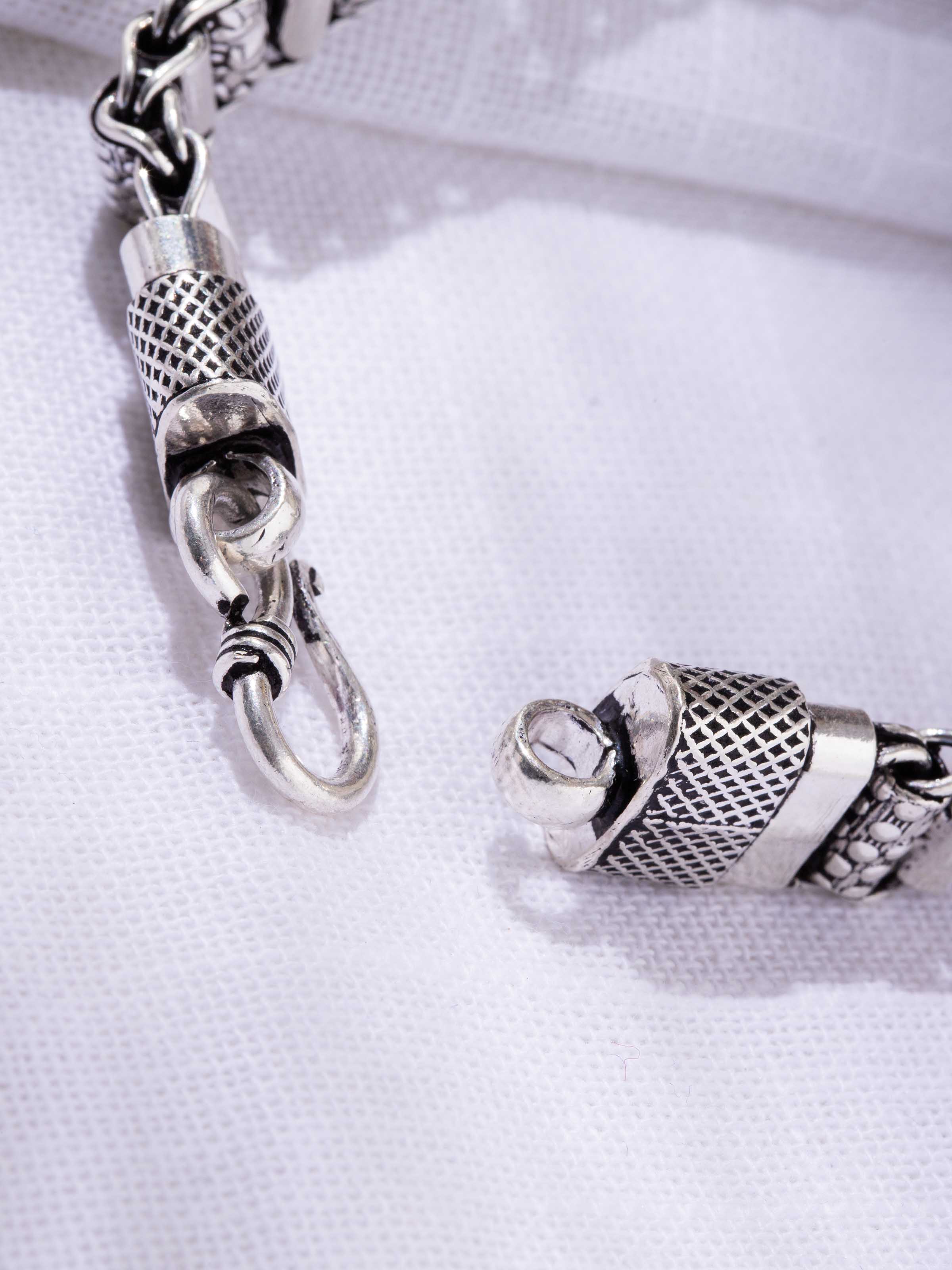 Close-up of links and clasp with textured detailing in oxidized silver.
