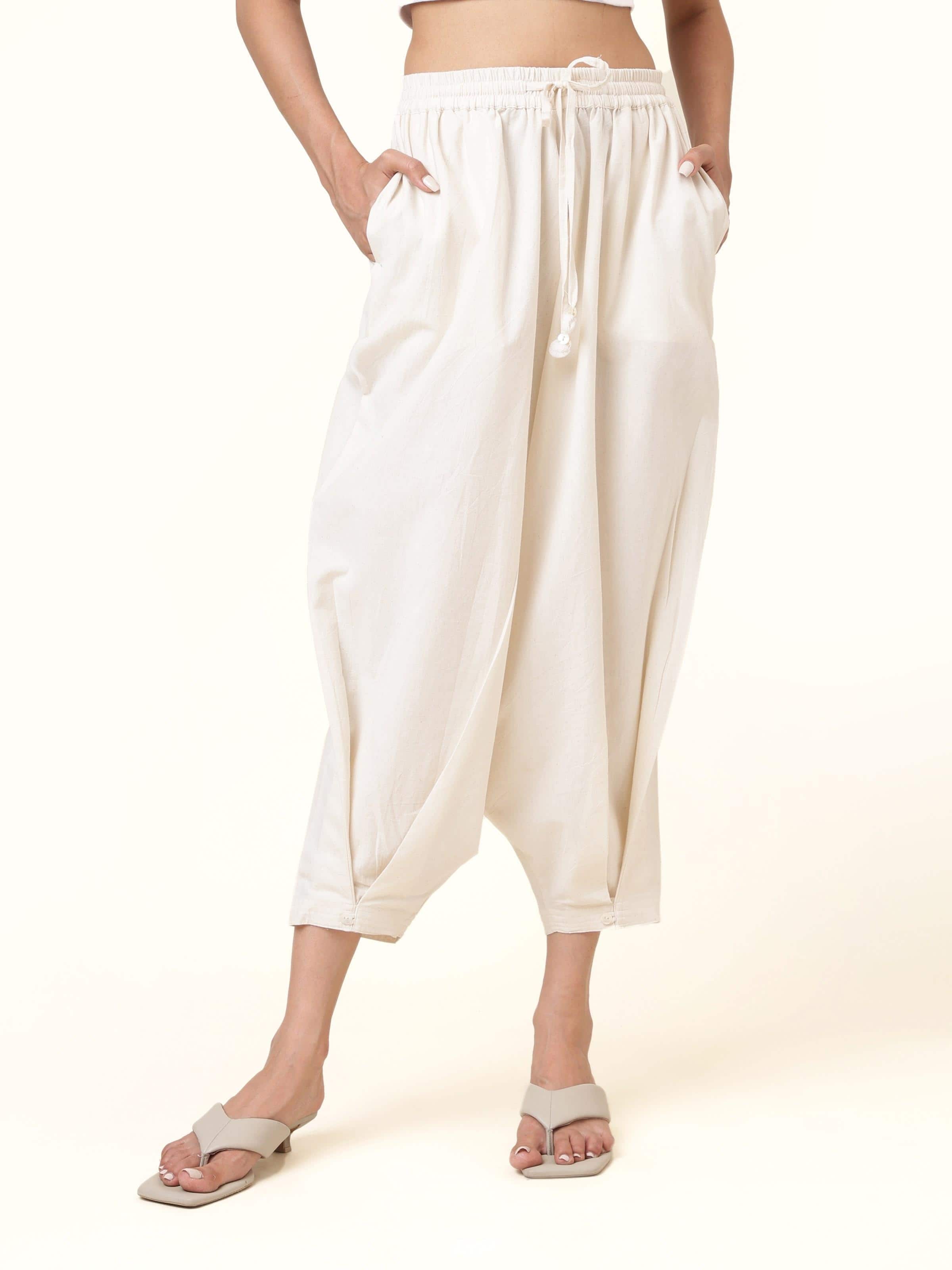 Front view of off-white cotton harem pants with pleated waist and relaxed fit
