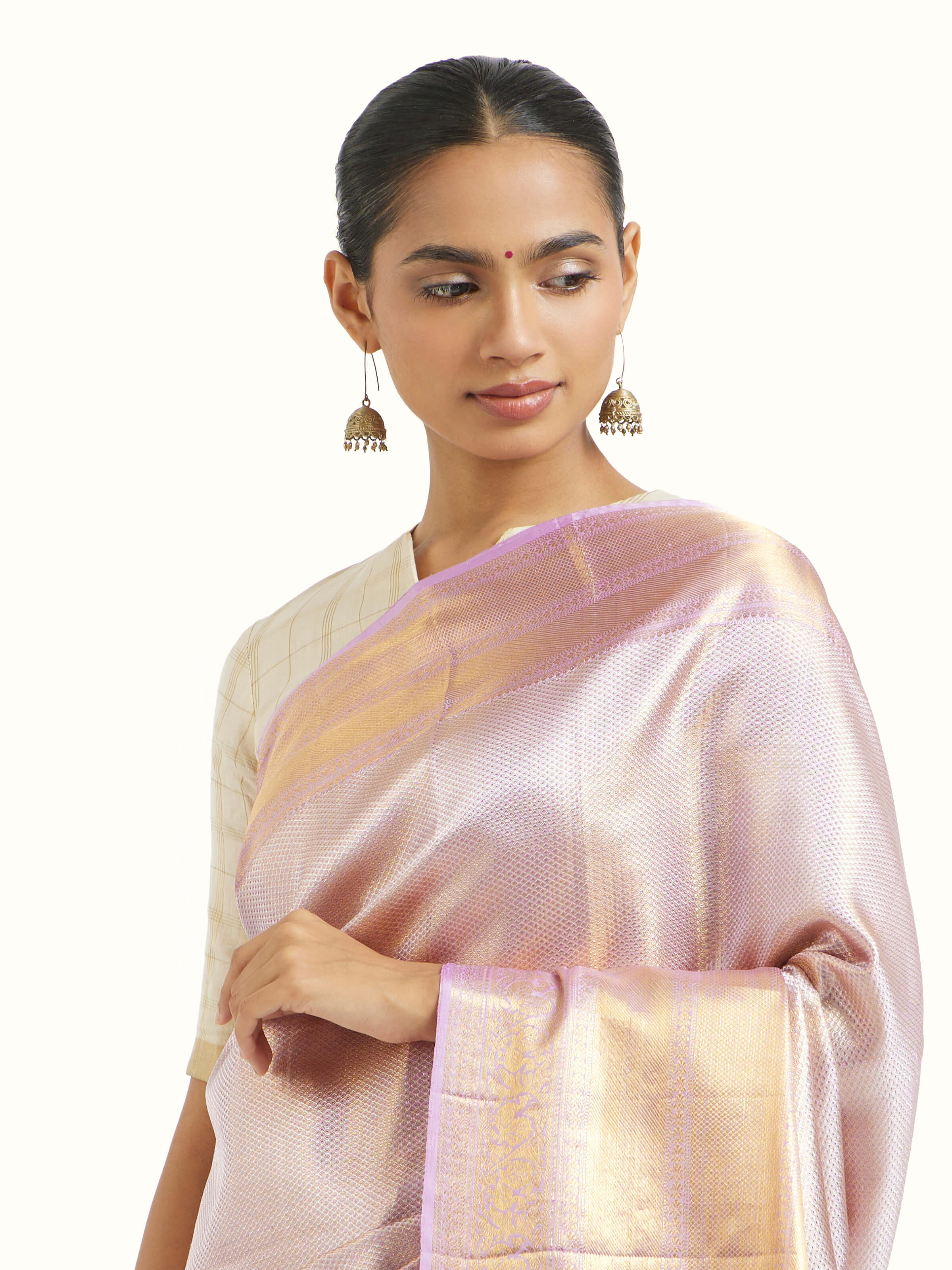 Angled view of beige silk Kancheepuram saree highlighting traditional weave and sheen