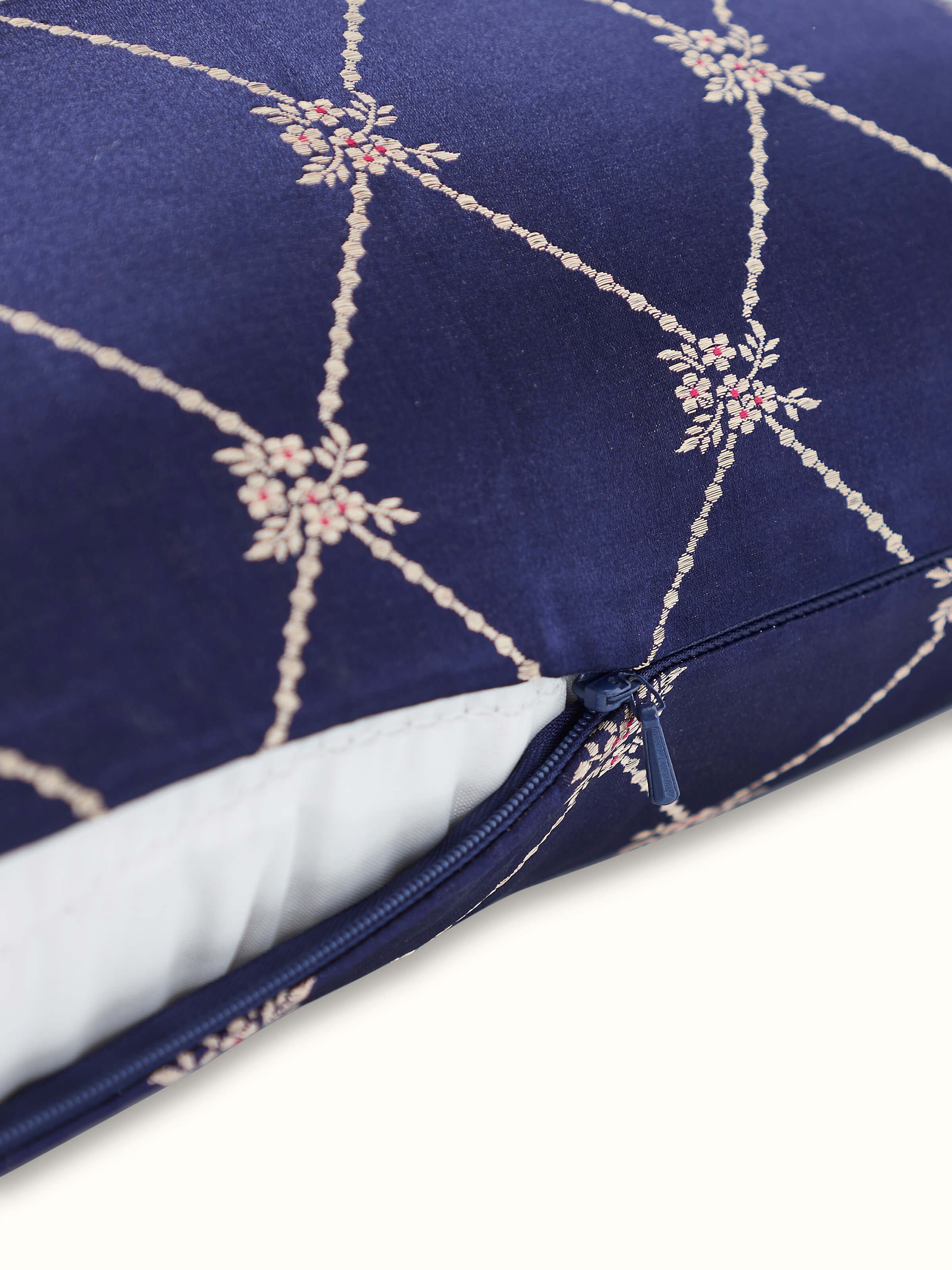 Angled view of Awadh Navy Blue Banarasi Handloom Silk Lumbar Cushion Cover, capturing its lustrous fabric and artisanal design.