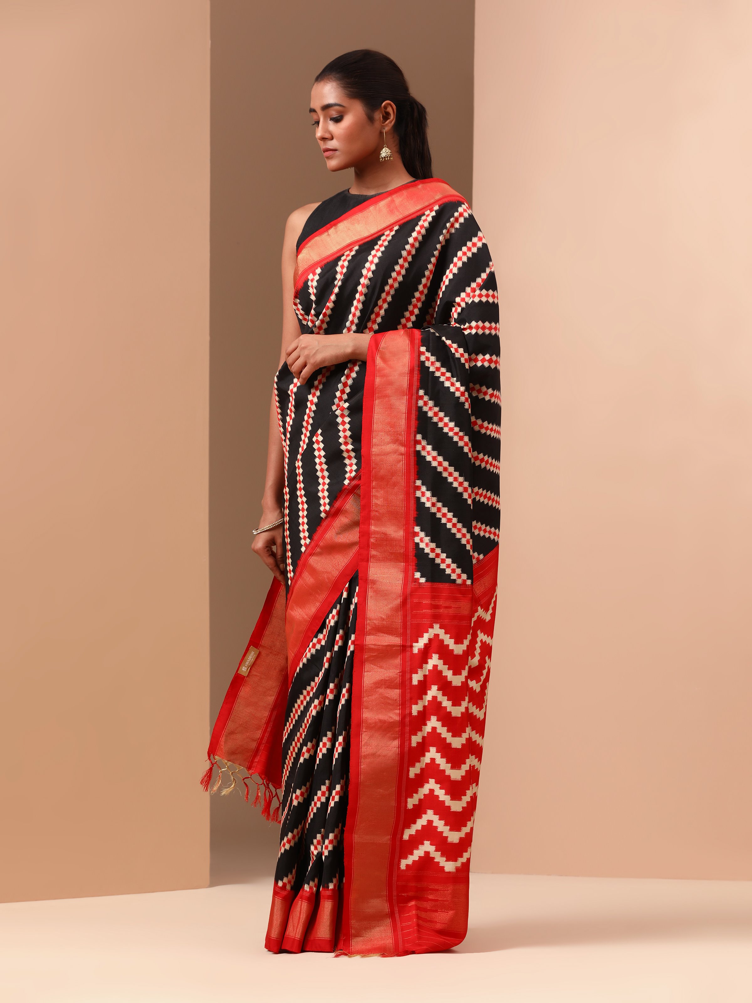 Close-up detail of Ikat patterns and silk texture on navy blue saree.