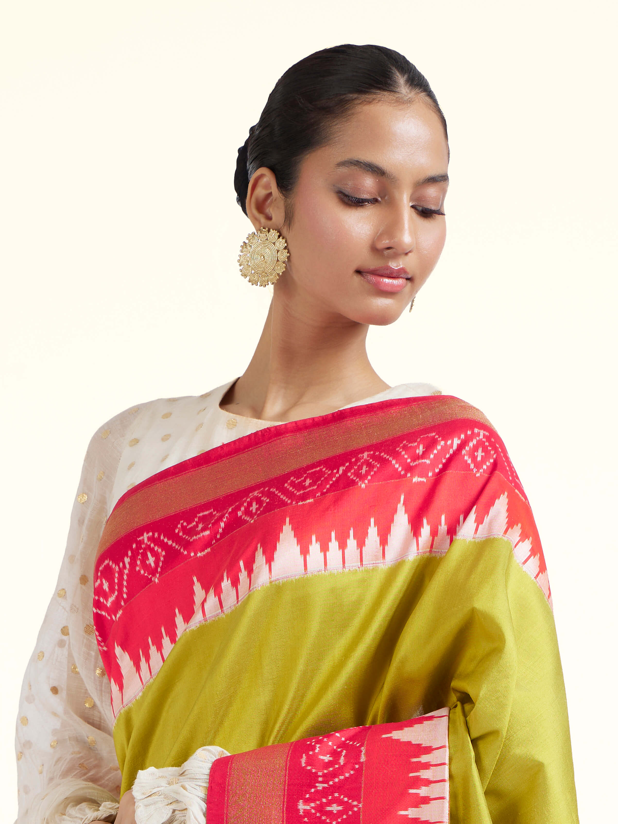 Angled view of mustard mulberry silk ikat saree highlighting ikat craftsmanship