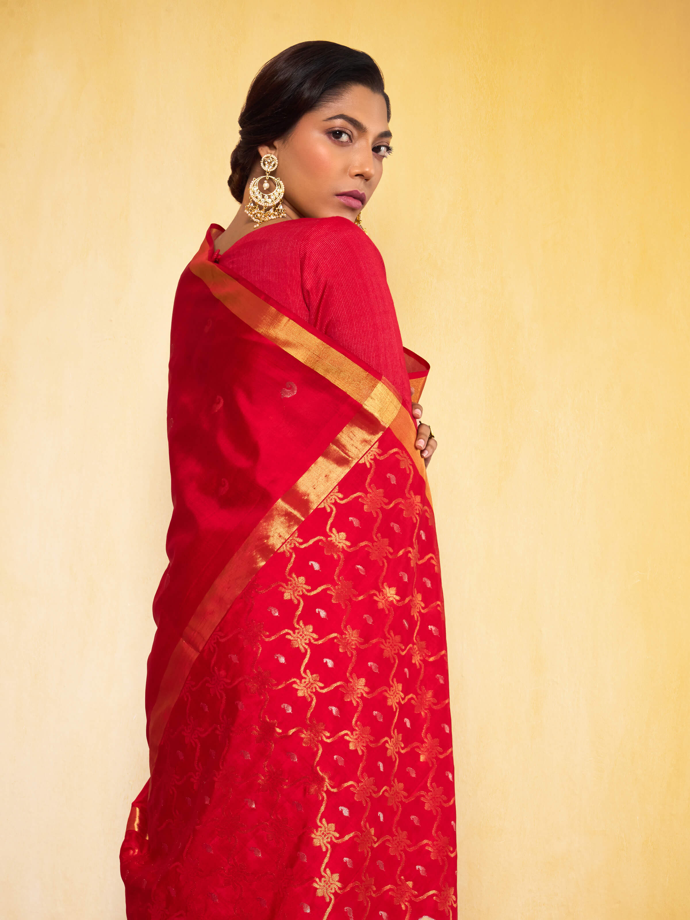 Side angled view of the red Uppada Jamdani saree highlighting the luxurious silk fabric.