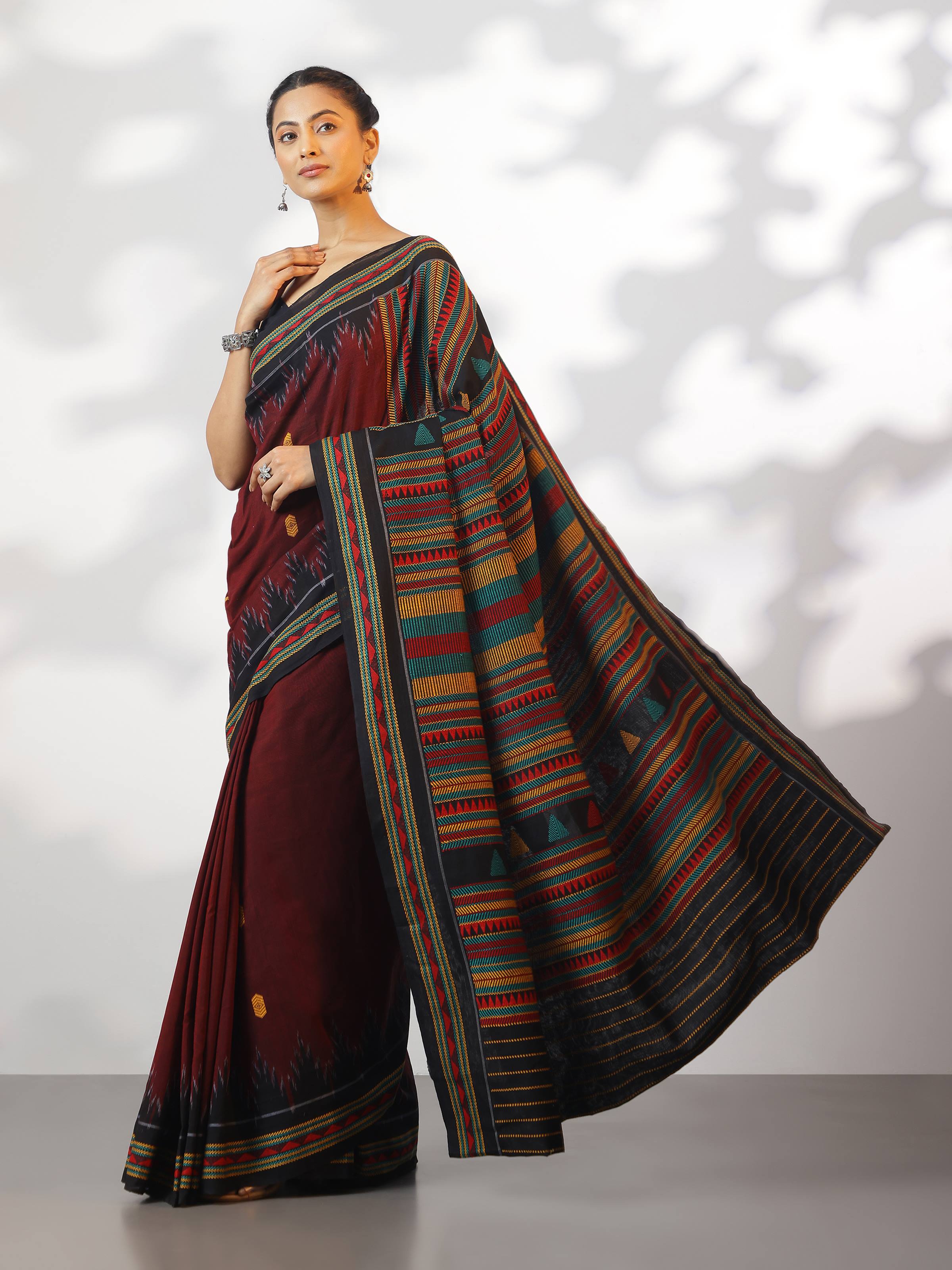 Lifestyle view of red Dongaria saree in cotton featuring traditional geometric tribal motifs