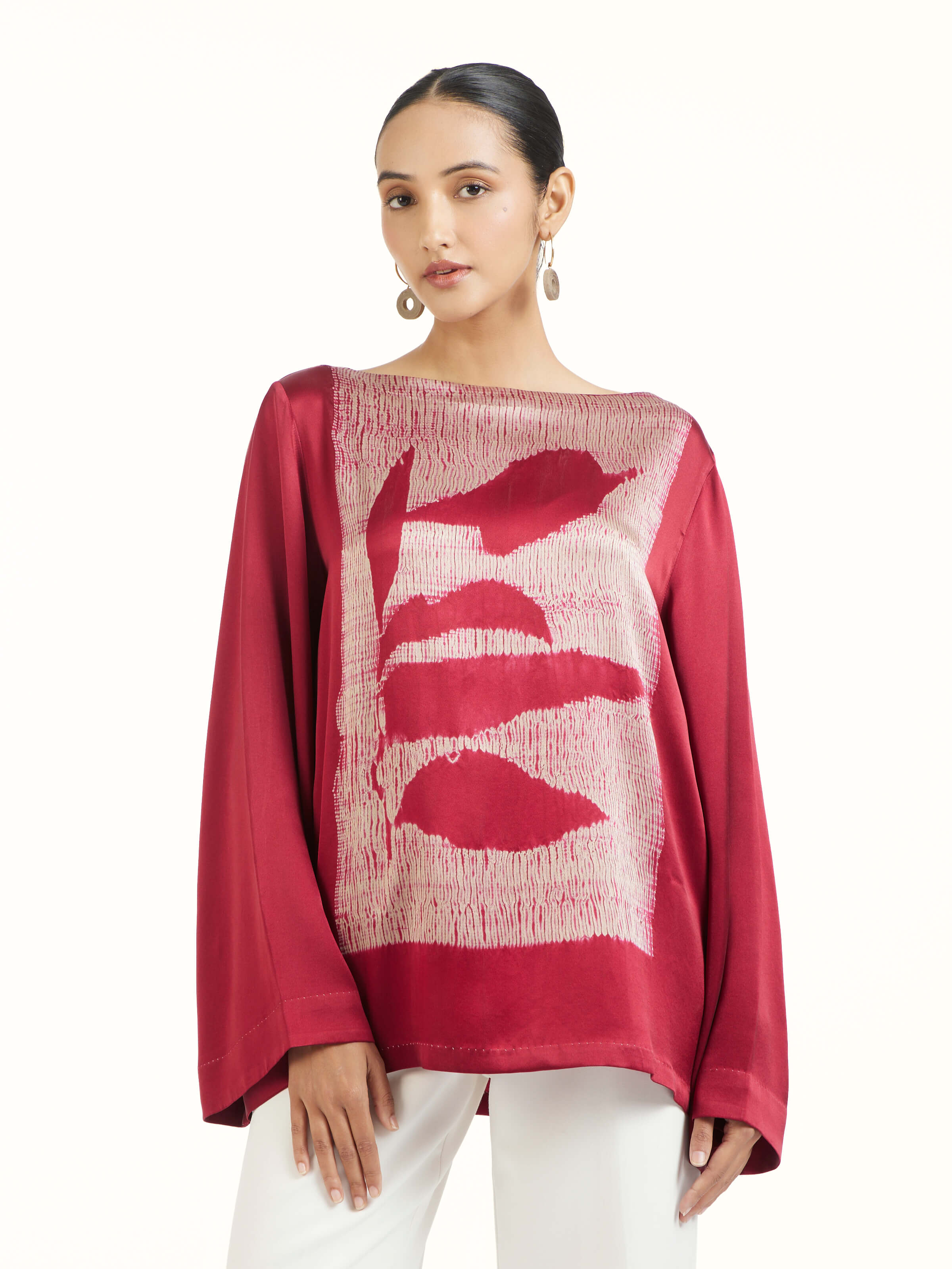 Angled view of red satin Shibori top emphasizing subtle Shibori detailing