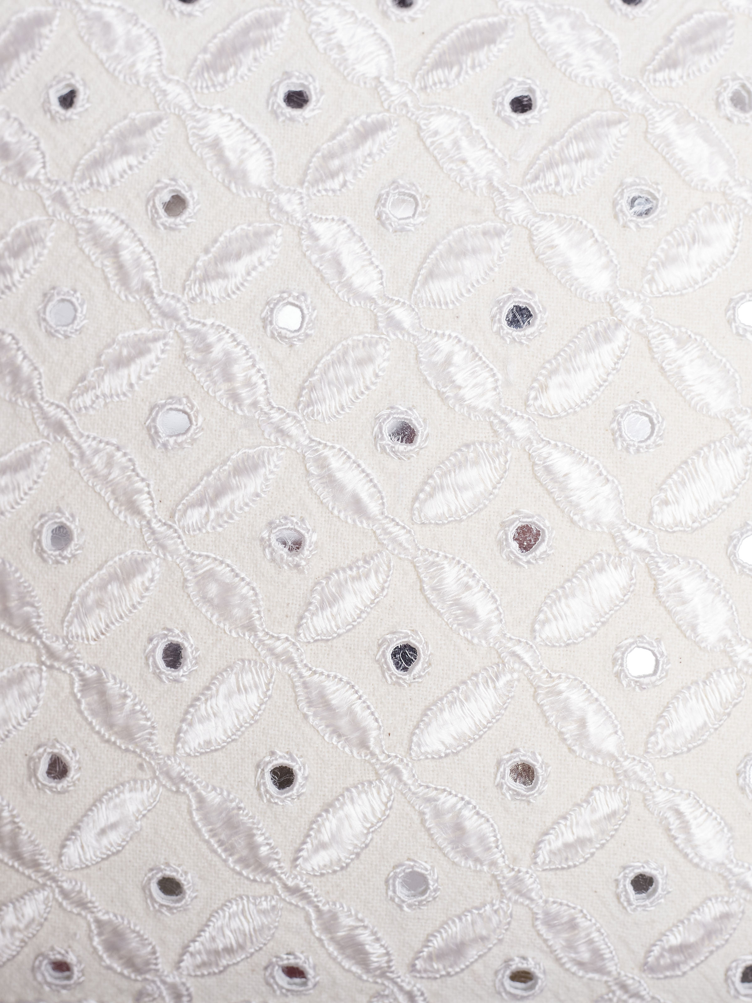 Close-up of allover Pakko hand embroidery on white cushion cover