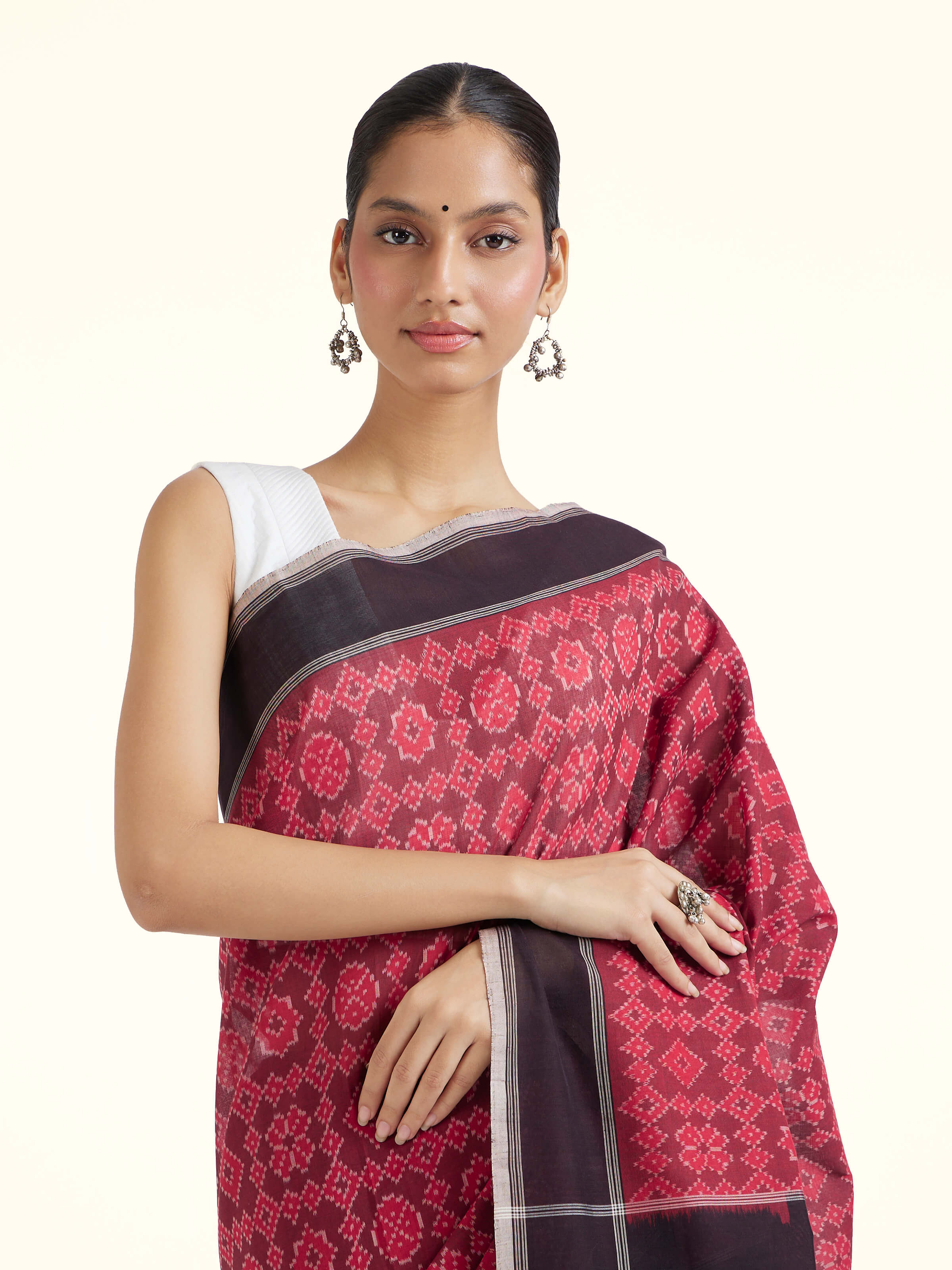Angled view of maroon mulberry silk ikat saree highlighting ikat weave and sheen