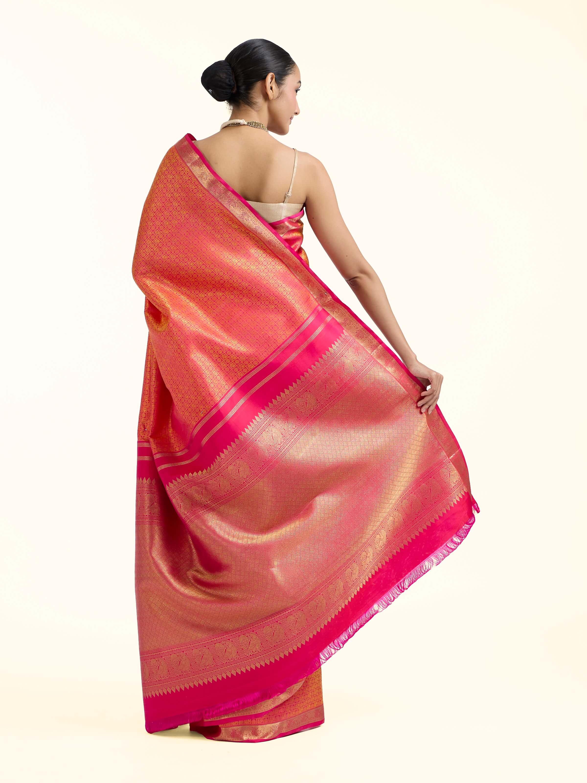 Back view of orange silk Kancheepuram saree displaying ornate pallu design