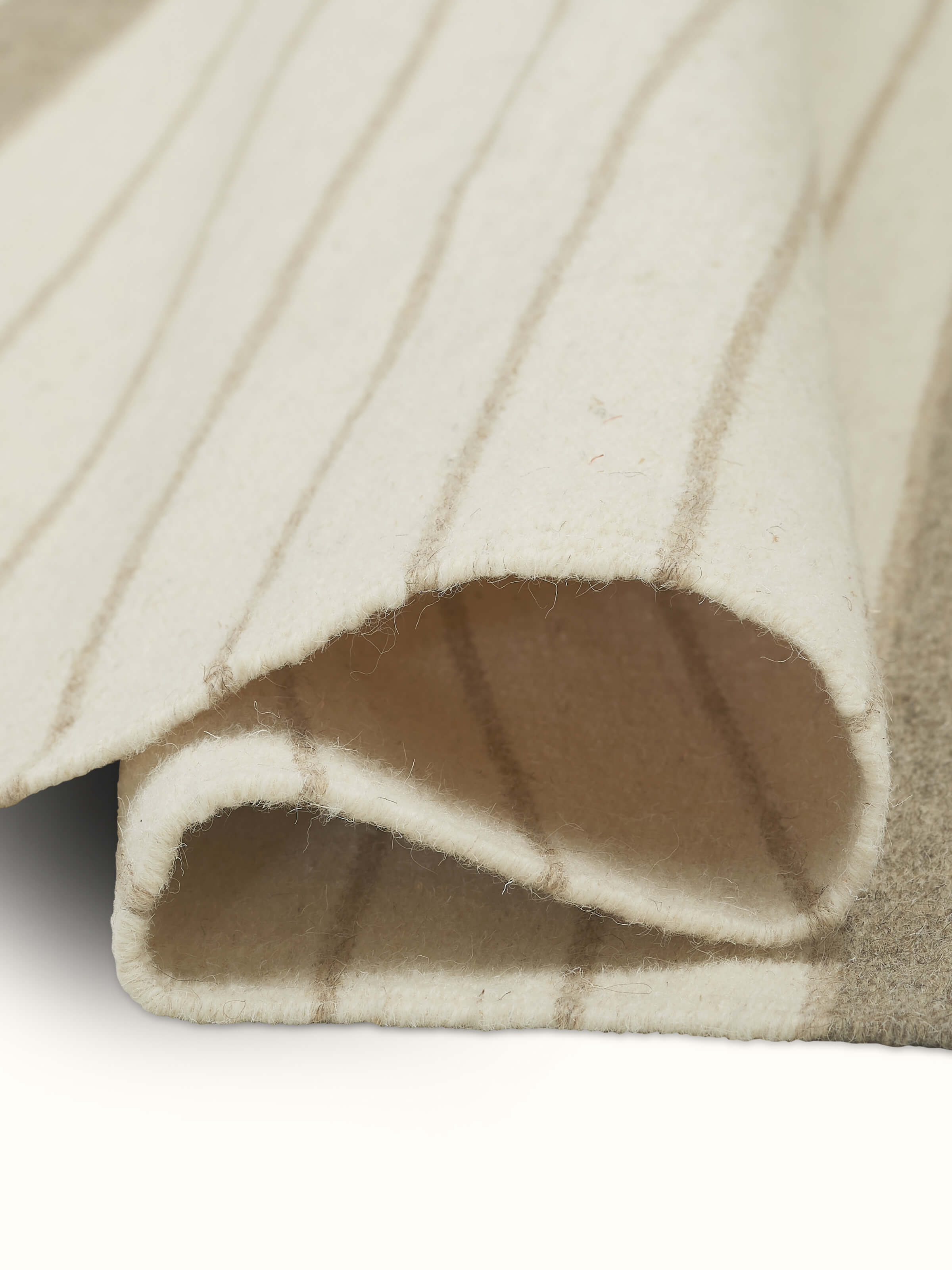 Nomad Stripes Beige Ivory Jawaja wool & cotton handloom dhurrie (3x5 ft) folded, emphasizing its texture and striped pattern.