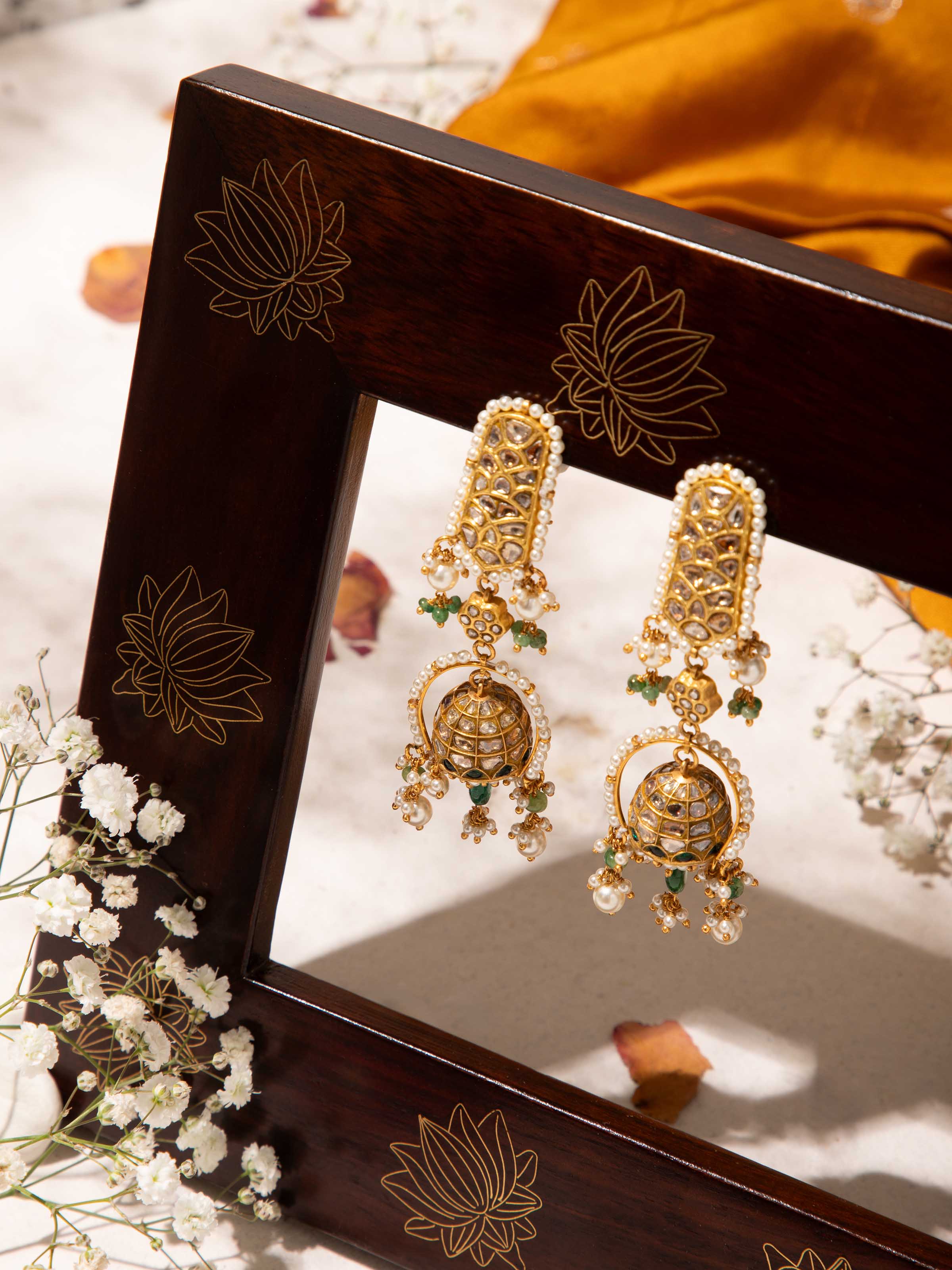 Side view of Thappa 22 karat gold drop earrings showcasing curved form and intricate patterns
