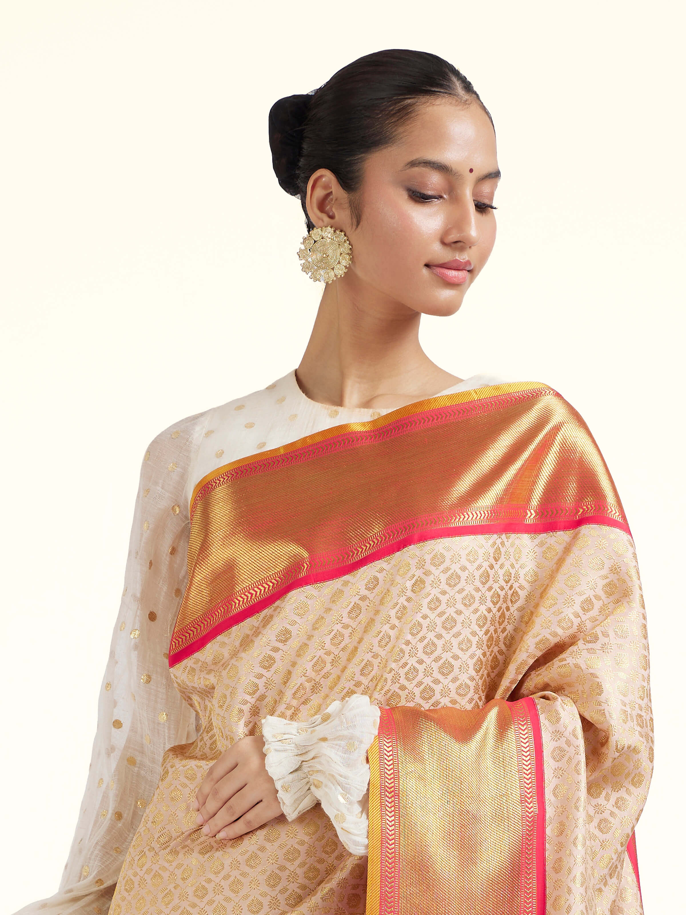 Angled view of onion pink silk Kancheepuram saree highlighting woven motifs