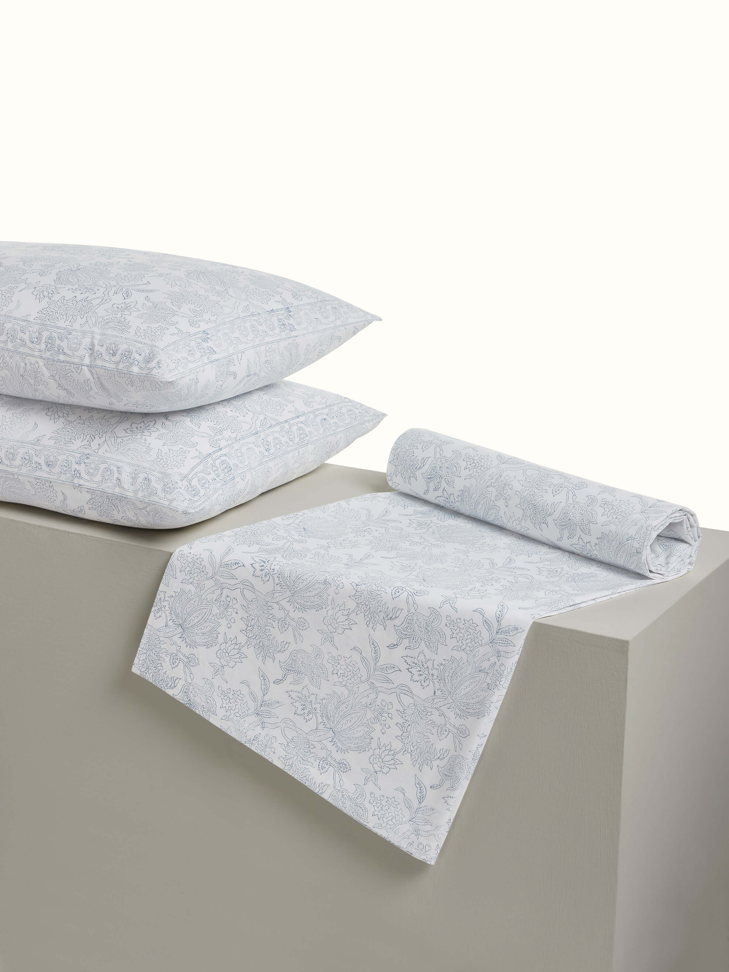 Angled view capturing pillow covers and floral motifs with precision block printing.