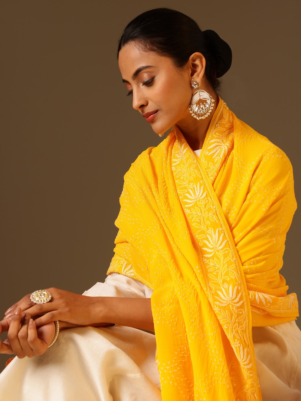 Angled view of yellow georgette bandhani tie and dye dupatta highlighting bandhani motifs