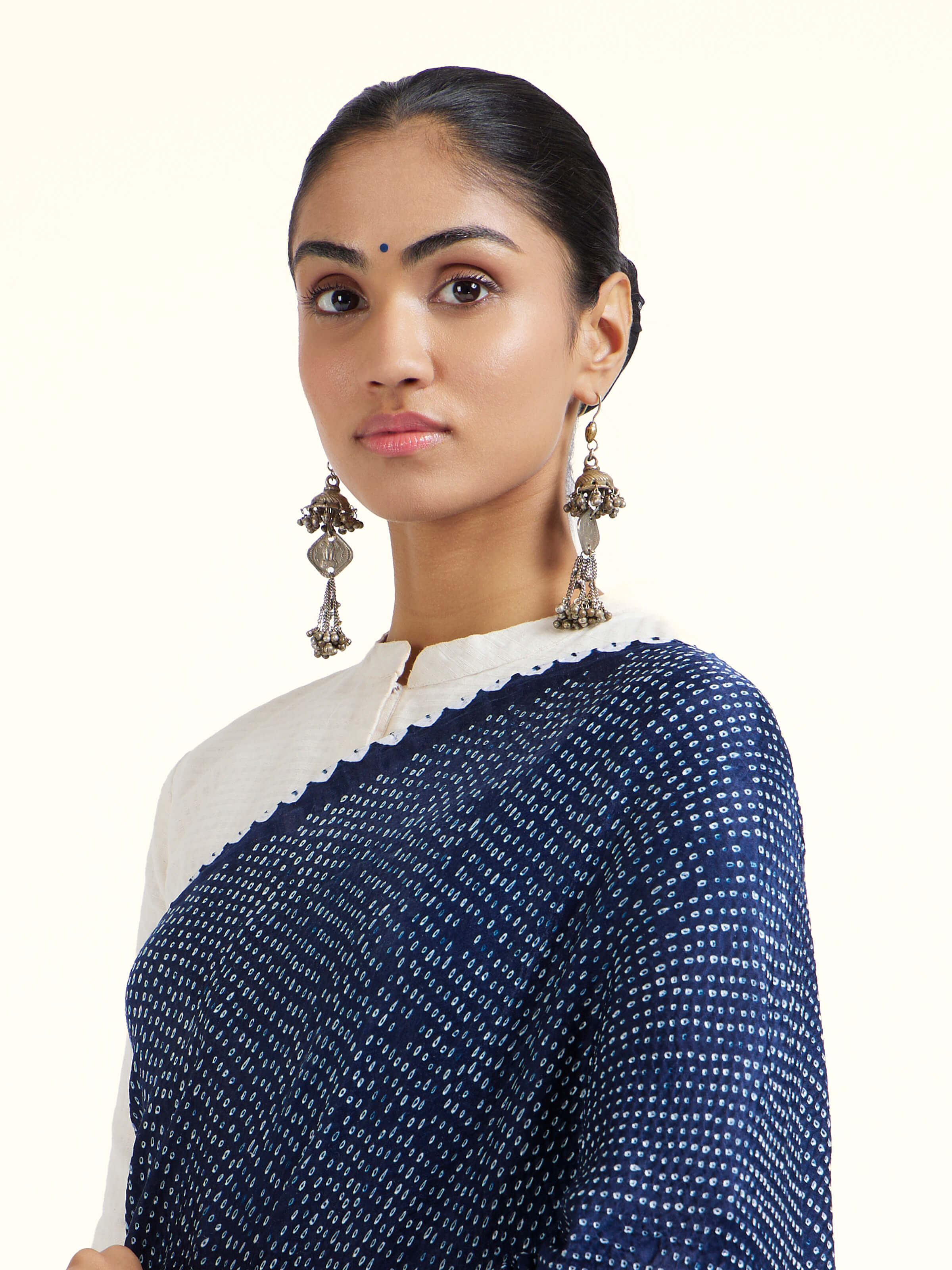 Angled view of black silk tie and dye bandhani saree highlighting bandhani motifs