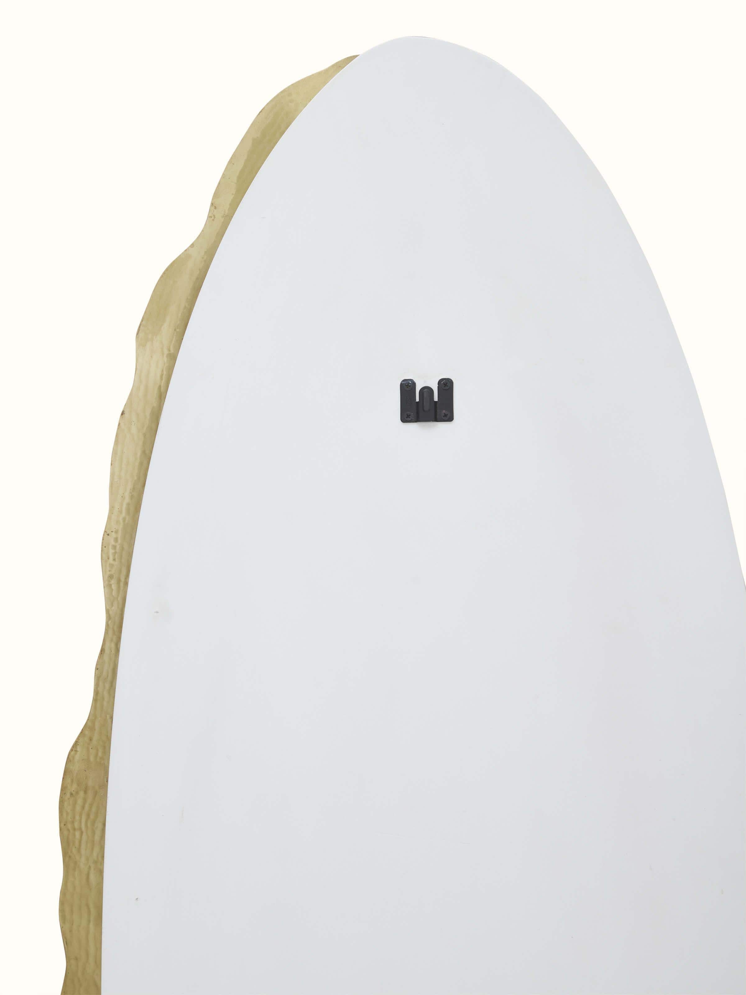 Detailed view of the brass frame of the full-length mirror, emphasizing its elegant finish and texture