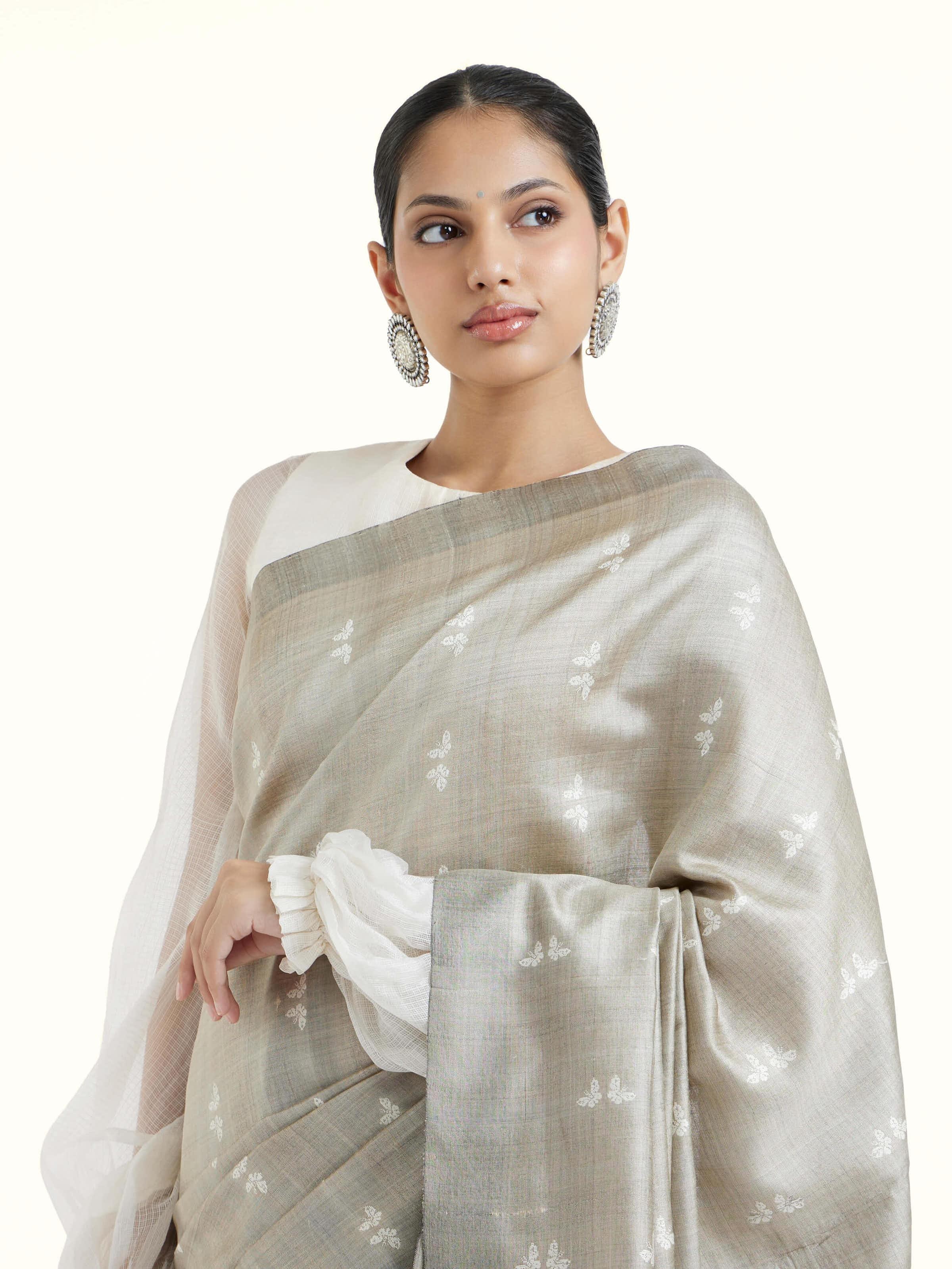 Angled view of grey tussar silk Odisha ikat saree emphasizing handcrafted ikat weave