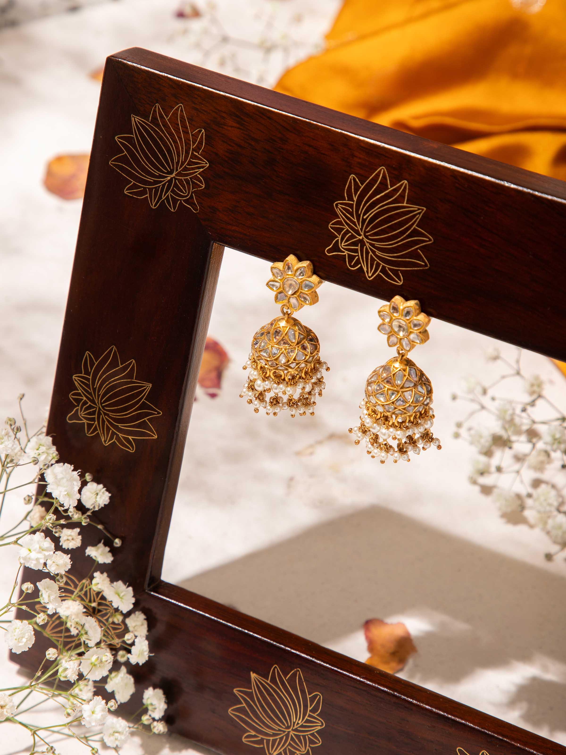 Lifestyle shot of gold jhumka earrings styled traditionally with festive attire