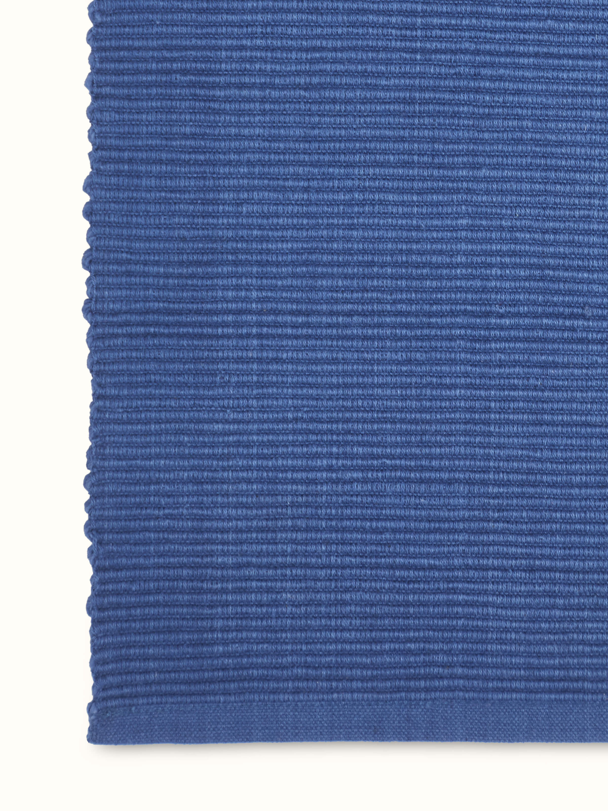 Detail shot of Vastav indigo cotton table runner showcasing handloom weave and clean hemmed edges.