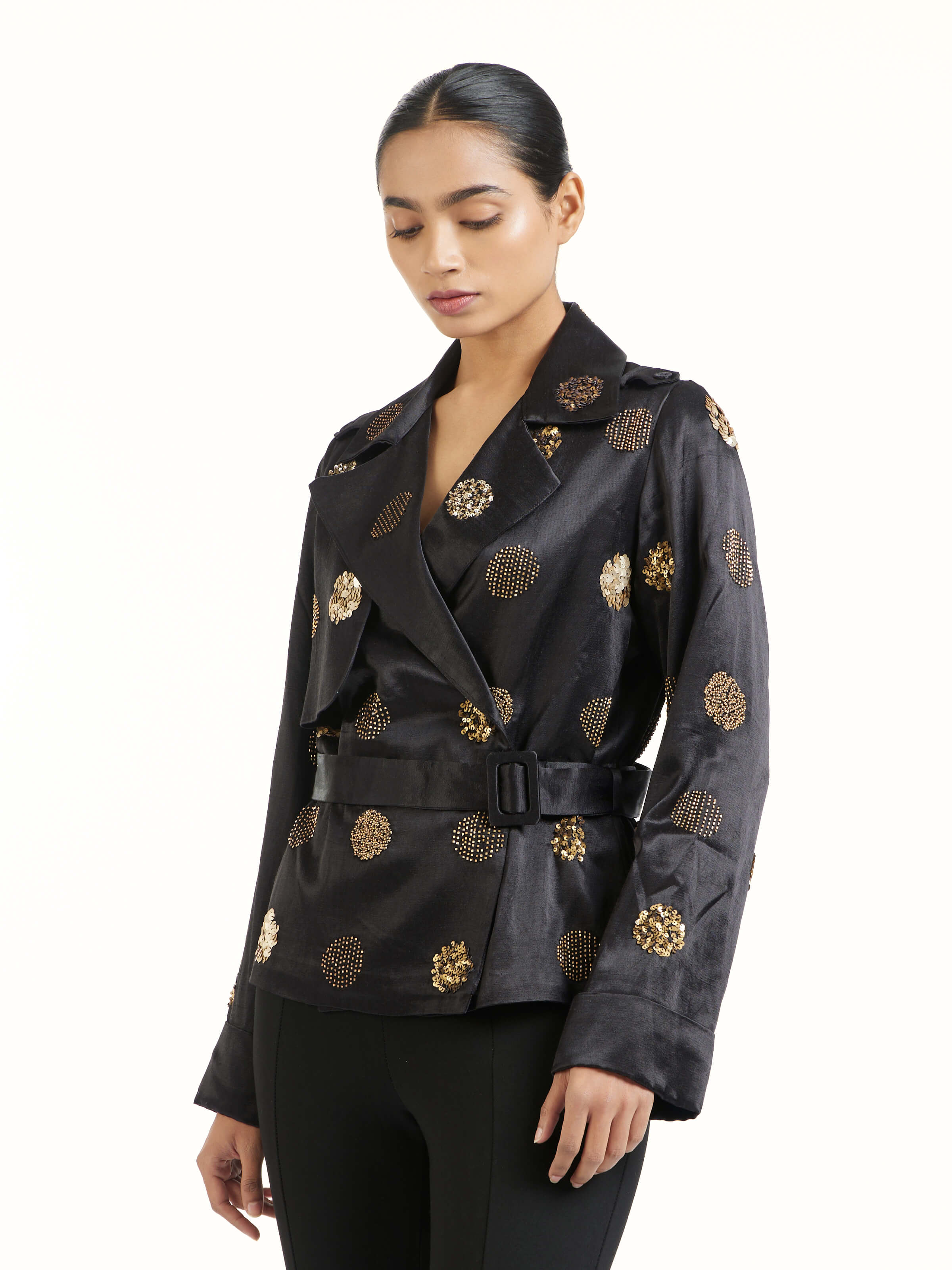 Angled view of black hand embroidered dotted gold jacket highlighting gold embroidery