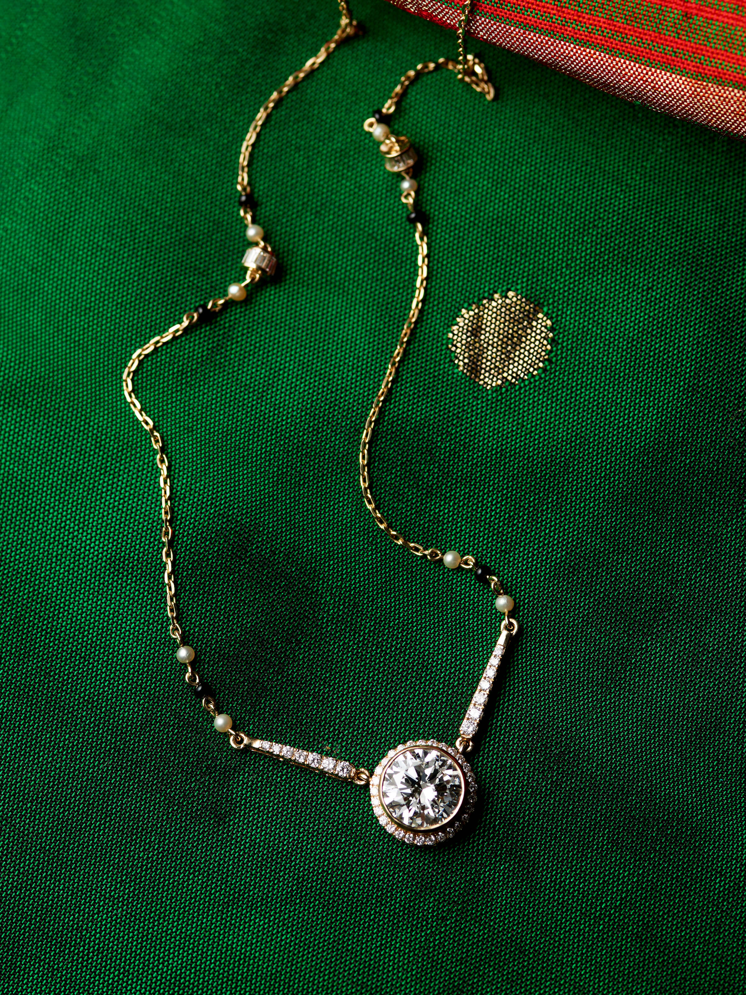 detail view of open setting 14 karat gold mangalsutra pendant
