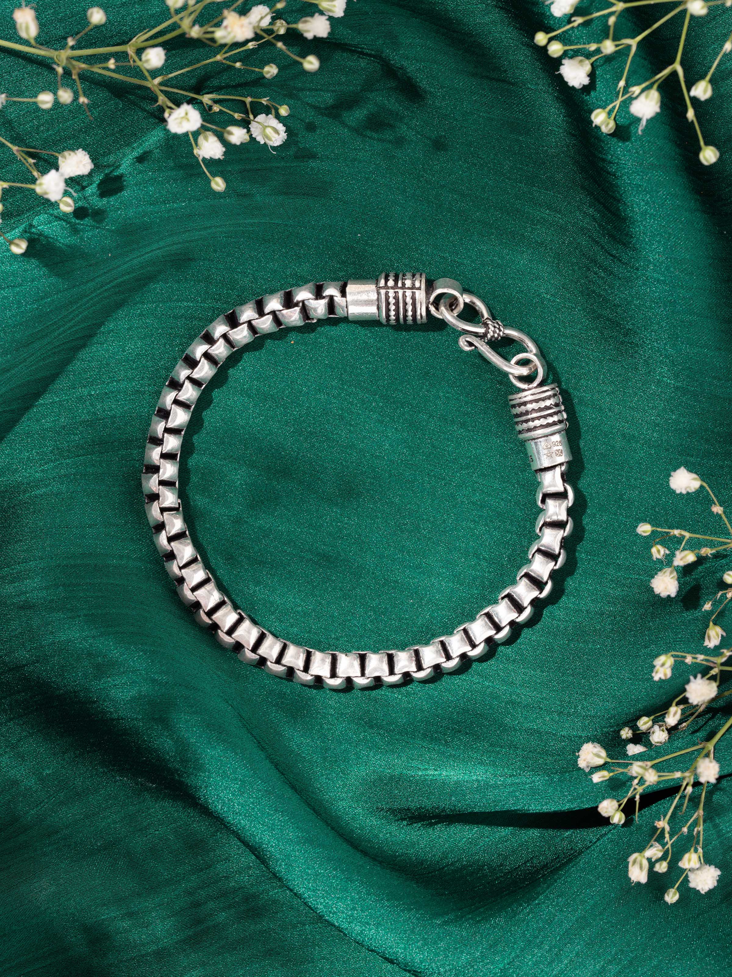 Lifestyle view of men’s silver bracelet worn on wrist to show rugged elegance