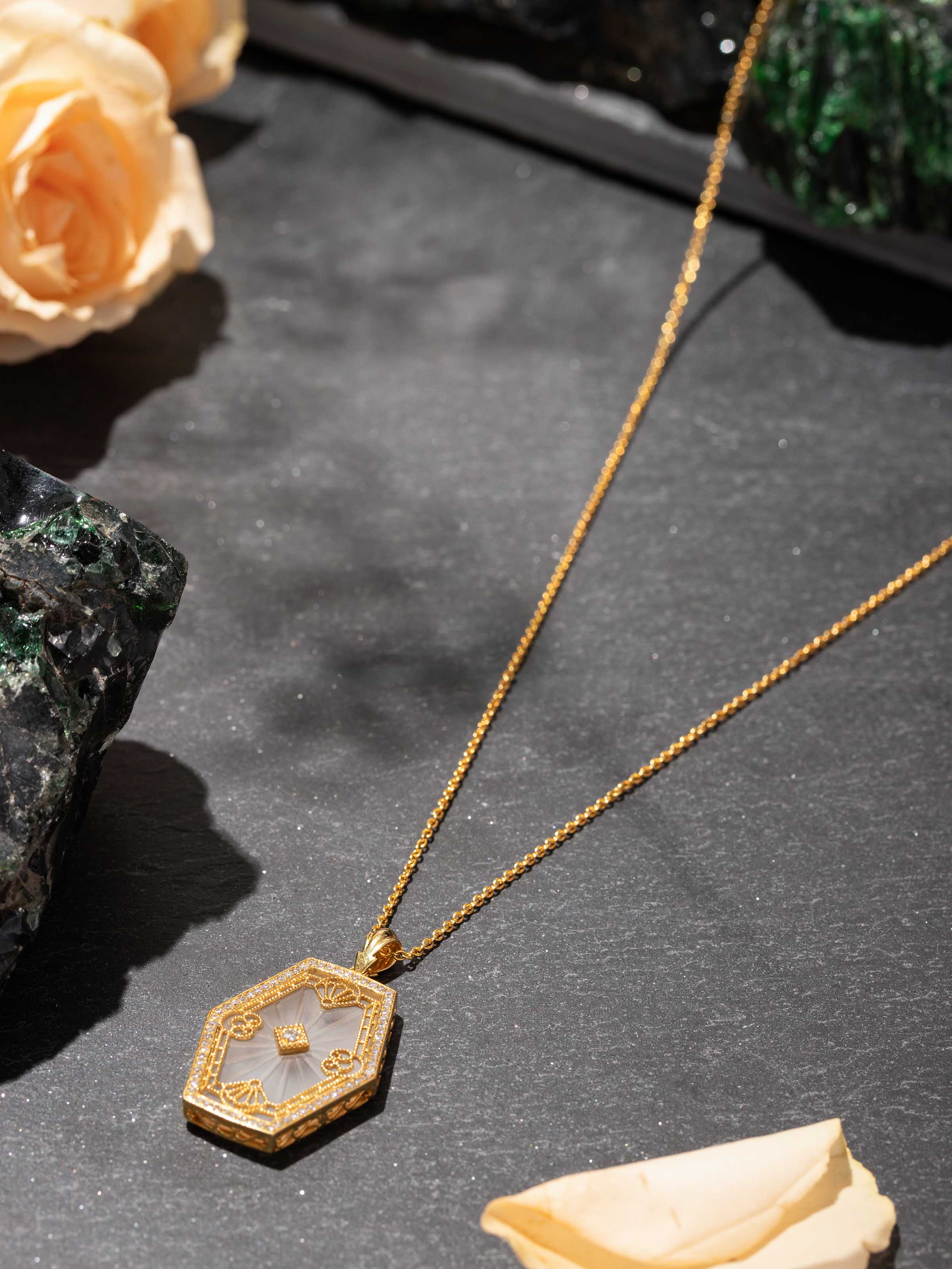 Lapidary gold pendant and chain close-up on display – Swadesh