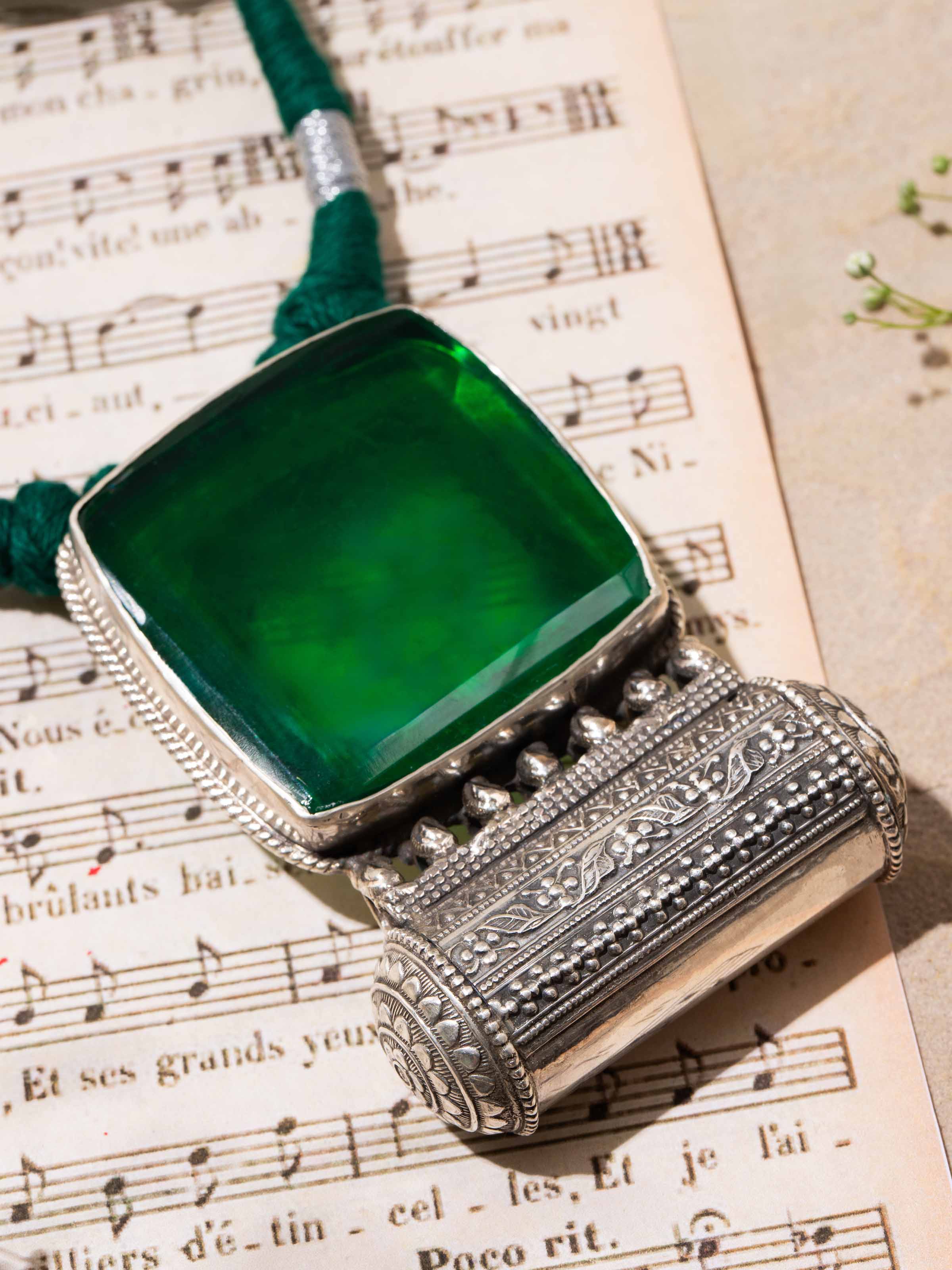 Detailed view of silver smithing collar necklace displaying artistic carving and subtle texture