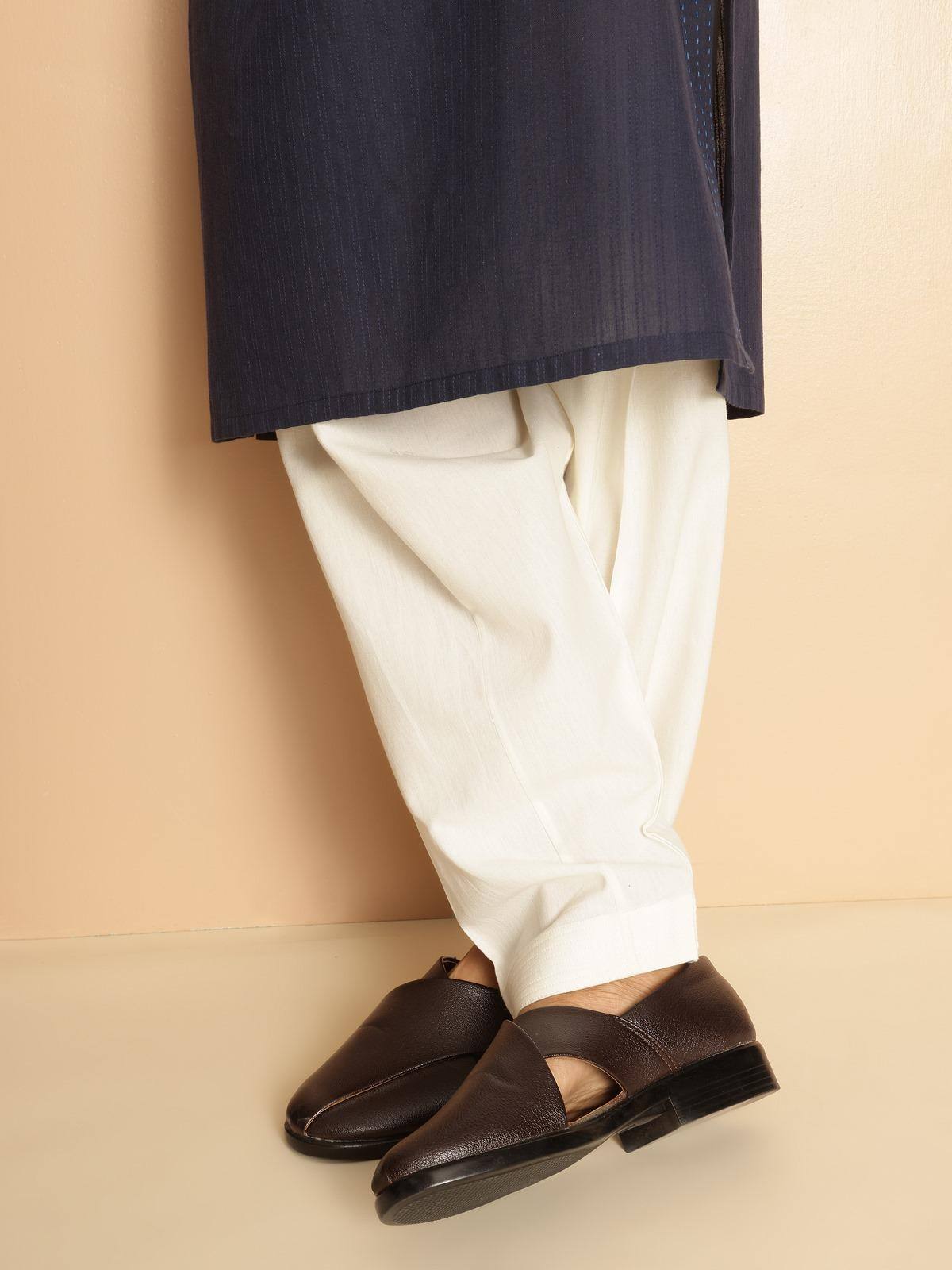 Side lifestyle view of off-white cotton salwaar highlighting drape and comfort in motion