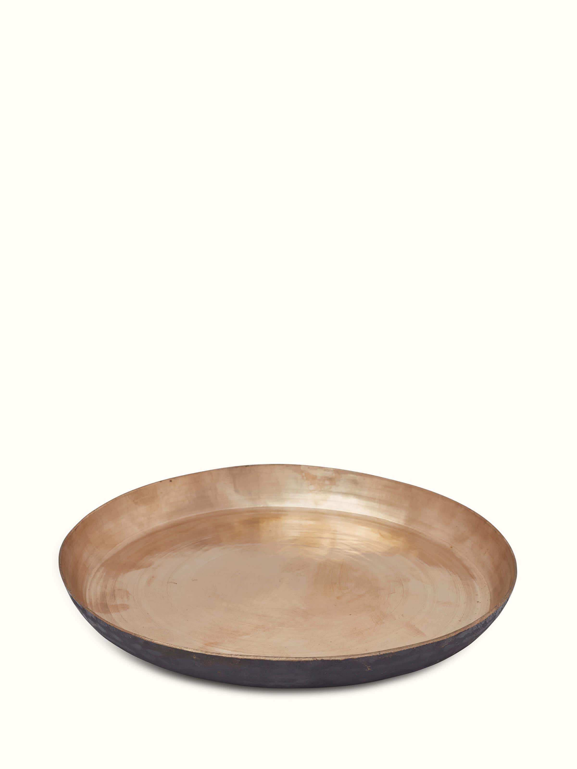 Close-up of bell metal dinner plate displaying detailed metalwork and design