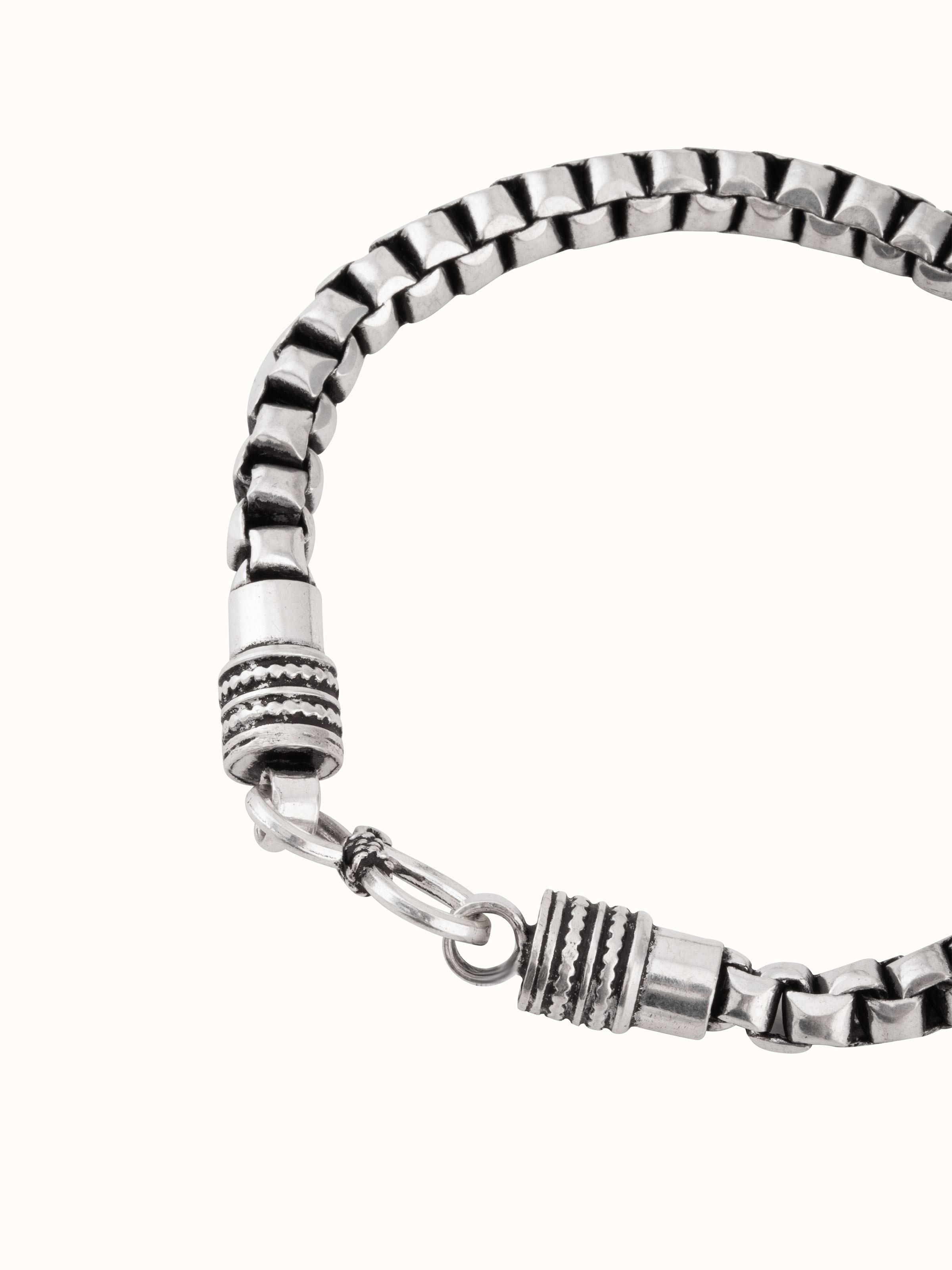 Overhead view of silver men’s bracelet arranged to showcase length and pattern
