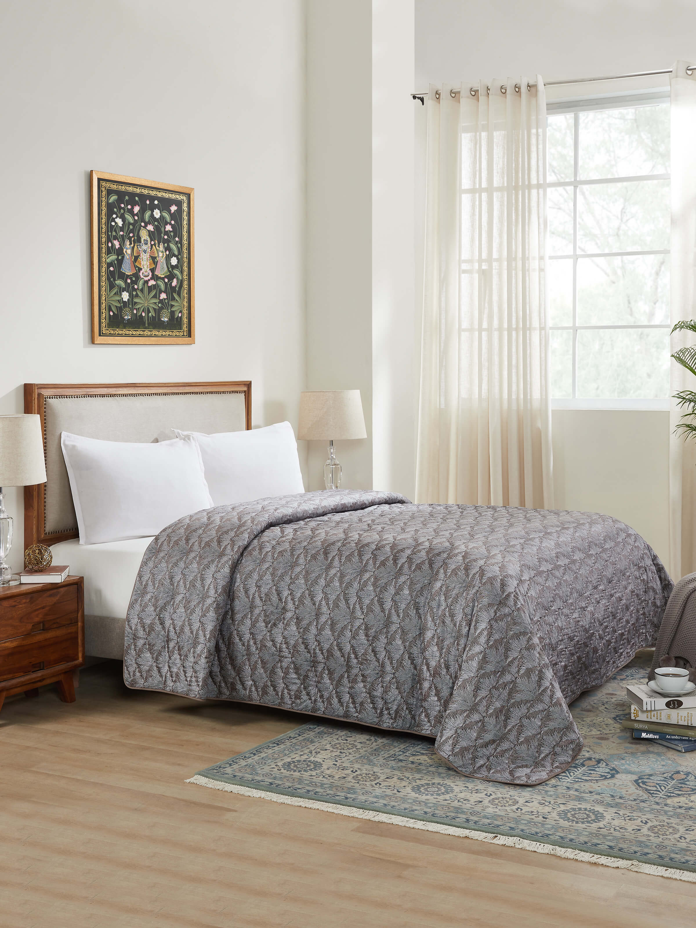 Lifestyle view of Parvat brown Sanganeri quilt spread on bed, styled with matching cushions.