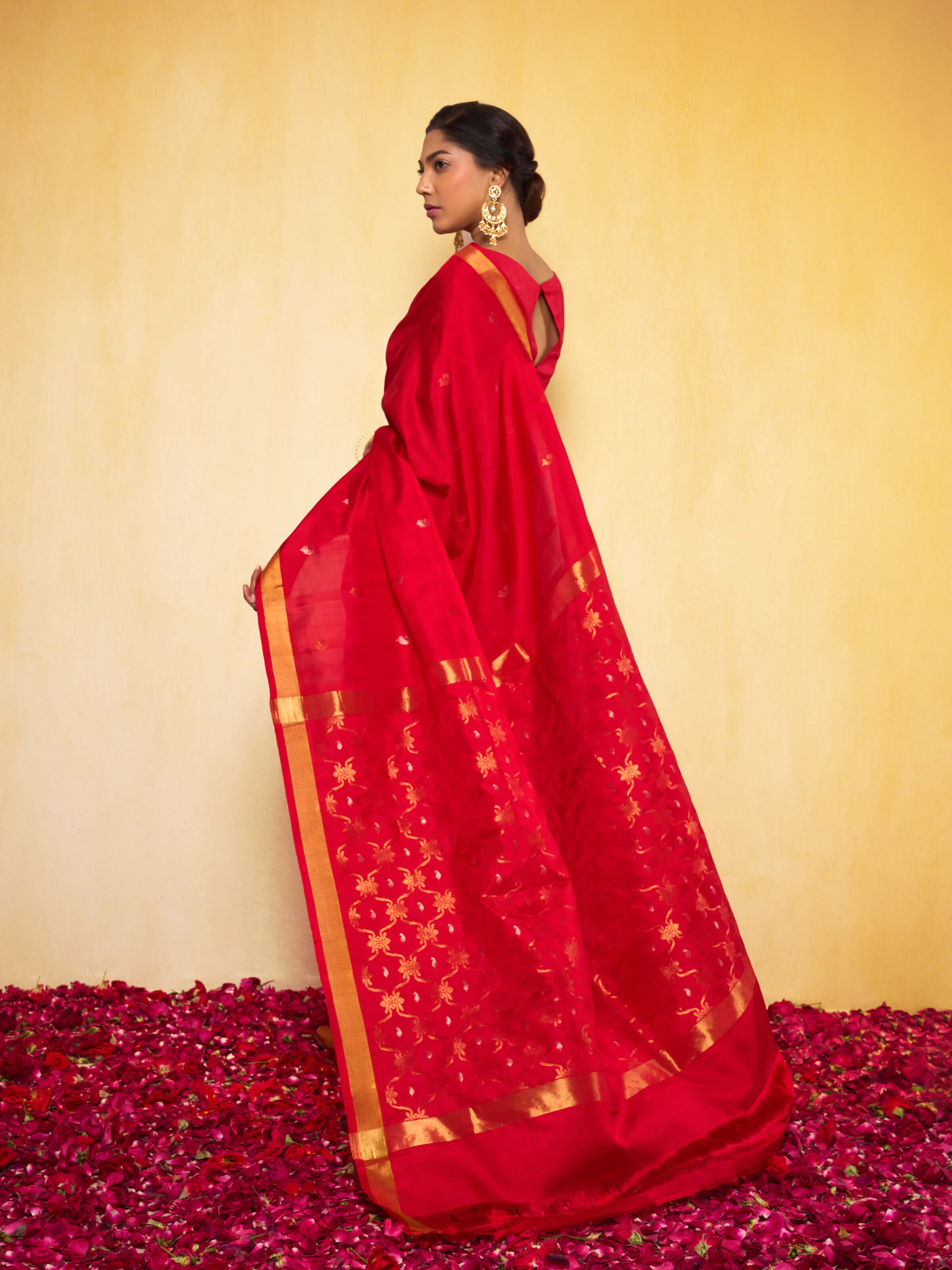Side view of model showcasing the red Uppada Jamdani saree with flowing drape and elegant design.