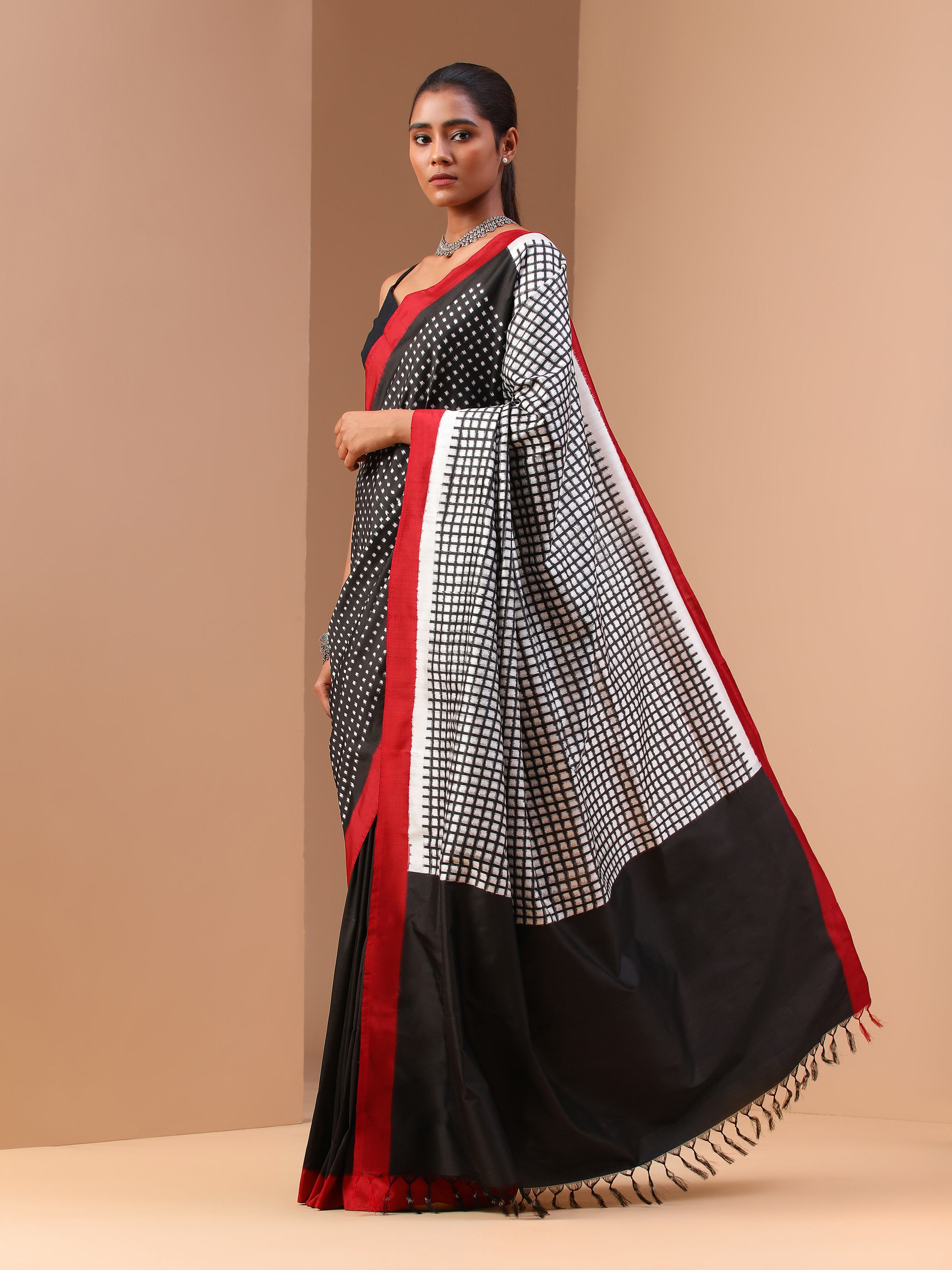 Angled lifestyle view of black silk double ikat saree displaying vibrant ikat weaving